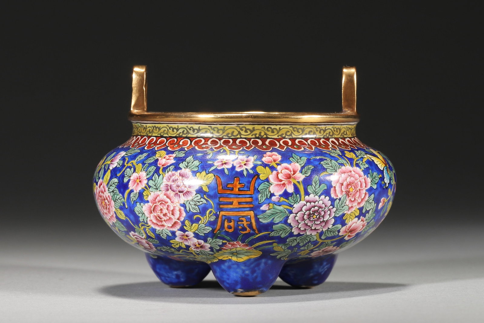 An Enameled Copper Incense Burner with Floral and Longevity Motifs, Qianlong Period: 8.5cm x 6.0cm,260.0g (3.35in x 2.36in,WT 0.5732lb)This copper incense burner features floral and longevity motifs on a vibrant blue enamel ground, with gilt accents and a "Qianlong" mark, embodying im