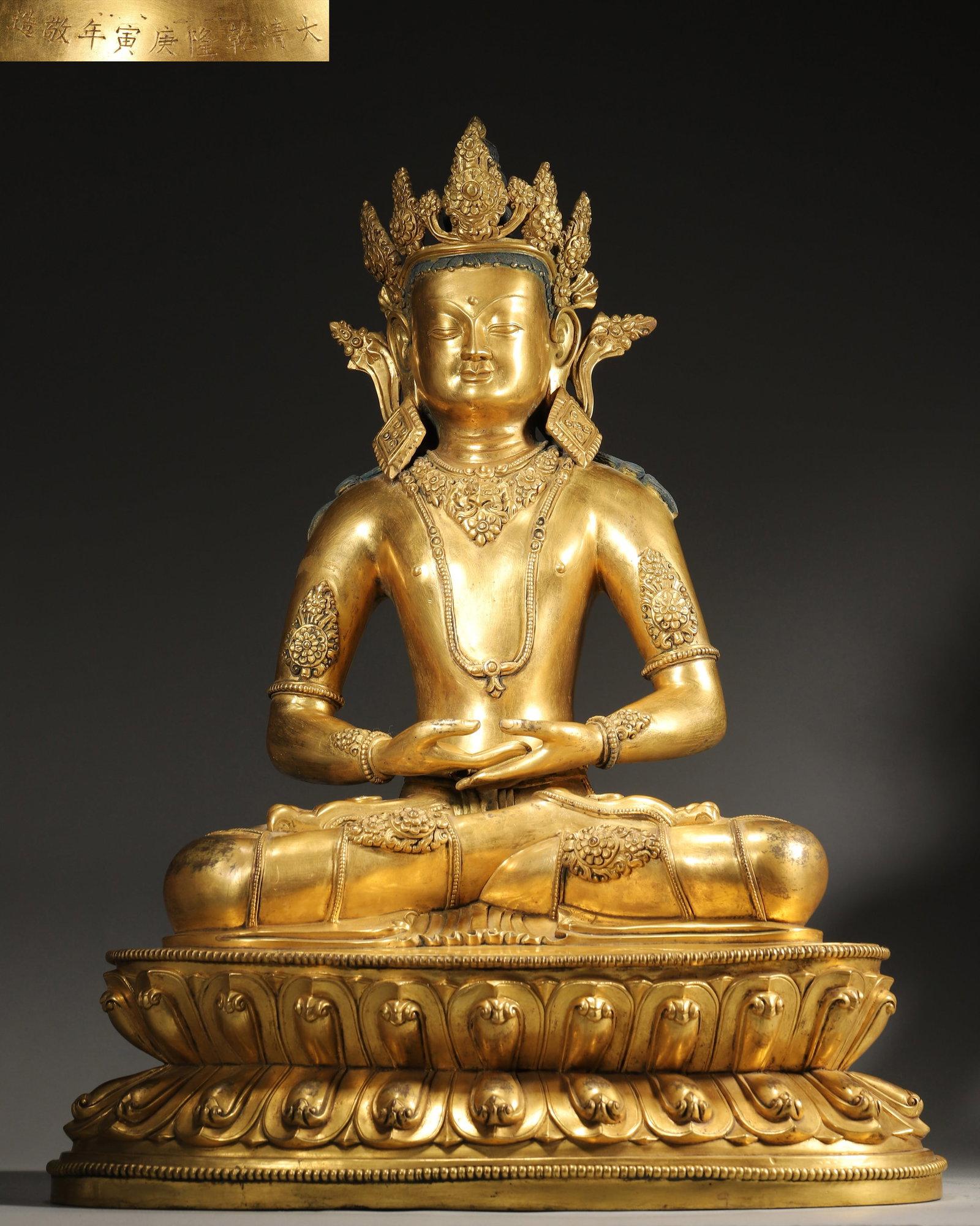 An Imperial Commissioned Gilt Bronze Amitayus Statue, Gengyin Year, Qianlong Period, Qing Dynasty: L 37cm (14.57 in); W 28cm (11.02 in); H 47.5cm (18.7 in); Wt 17050g (37.59 lb)An imperial commissioned gilt bronze Amitayus statue from the Qianlong period of the Qing Dynasty, with a clear inscriptio