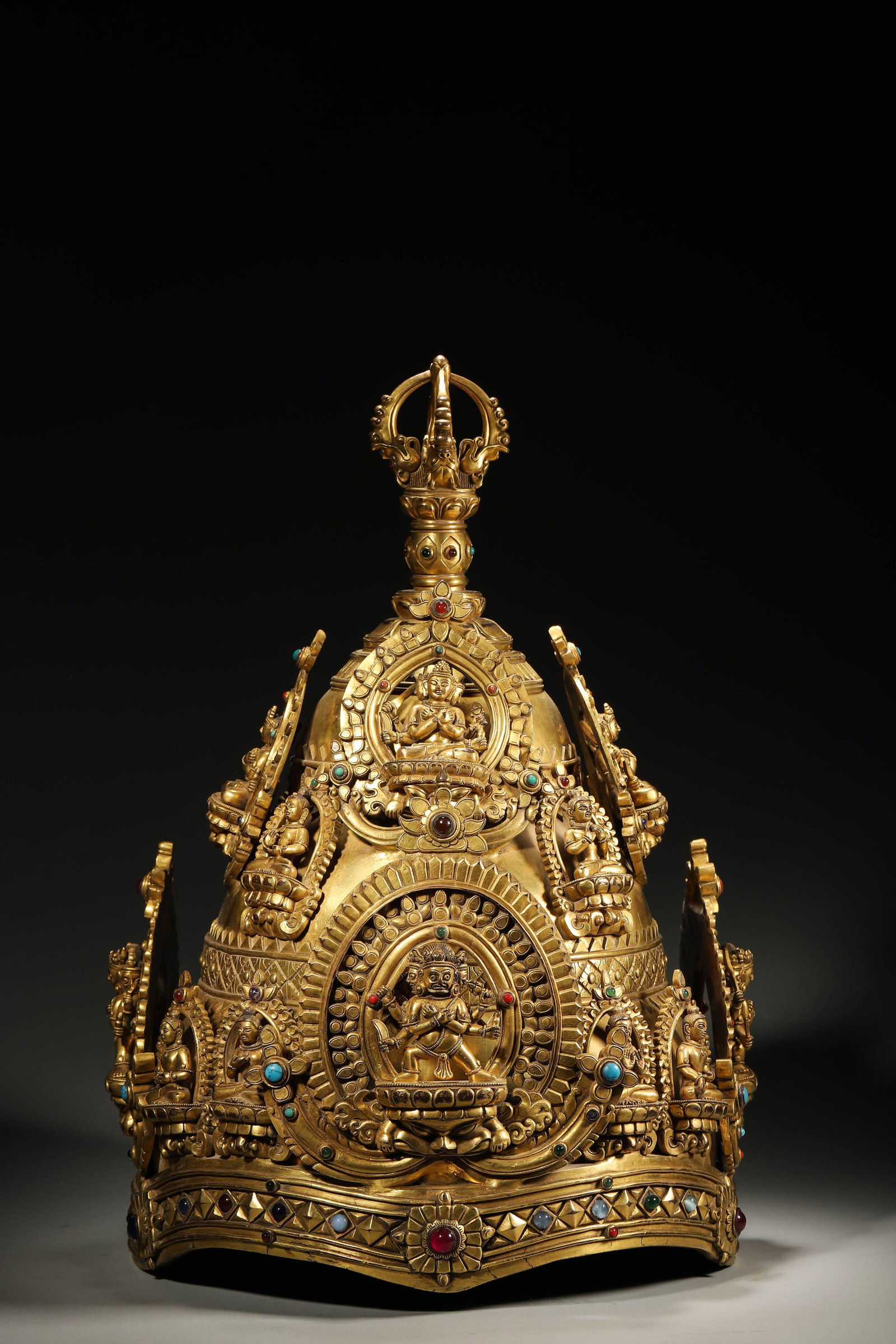 A Ming Dynasty Tibetan Gilt-Bronze Jewel-Inlaid Royal Crown: L 28cm (11.02 in); W 28cm (11.02 in); H 44cm (17.32 in); Wt 14.5kg (31.97 lb)A Ming Dynasty Tibetan gilt-bronze jewel-inlaid royal crown, adorned with multi-colored gems and carved Buddha figures. Wit