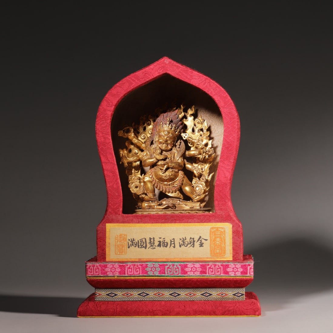 A Gilt Bronze Six-Armed Mahakala Statue, Qing Dynasty: Buddha H 13cm (5.12 in); Buddha L 10cm (3.94 in); Buddha W 6cm (2.36 in); Wt 474g (1.04 lb)A Qing Dynasty gilt bronze six-armed Mahakala statue, with fierce expression, holding ritual implements, tram