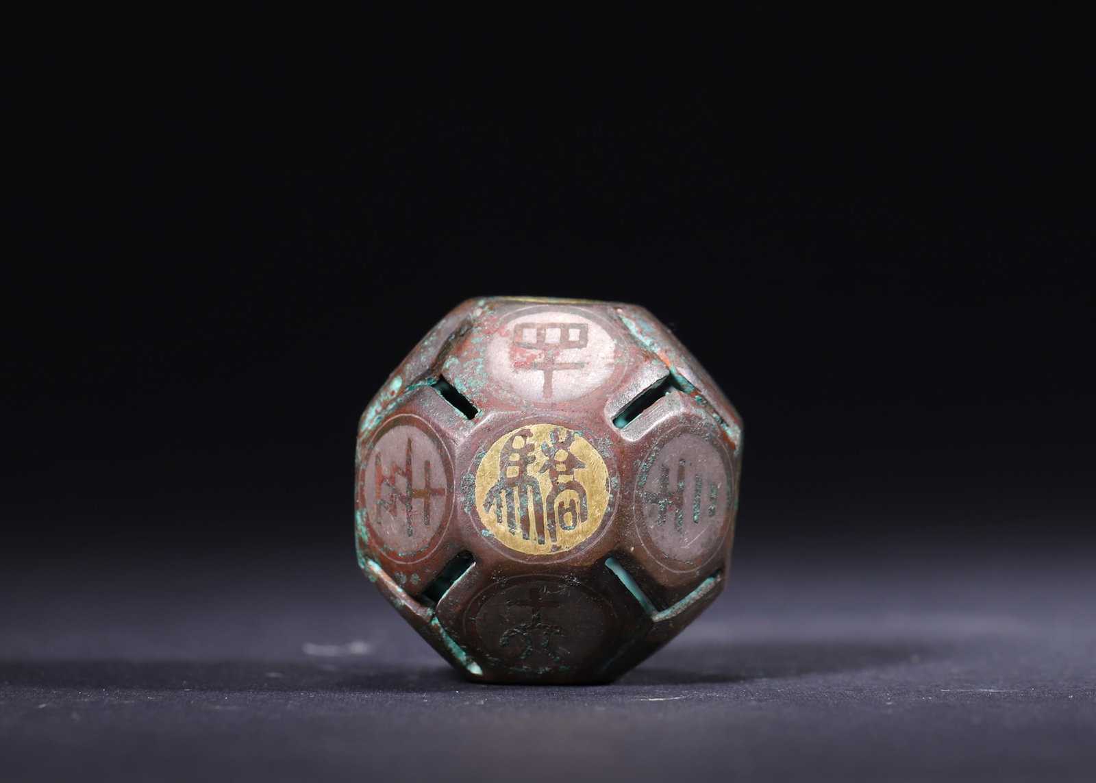 A Bronze Liubo Dice with Gold and Silver Inlay, Han Dynasty: Diameter 4.0cm (1.57in), Weight 68.0g (0.15lb)This Han Dynasty wine-order dice is cast in bronze with fine gold and silver inlay. Its multi-faceted surfaces bear characters for drinking games, reflect