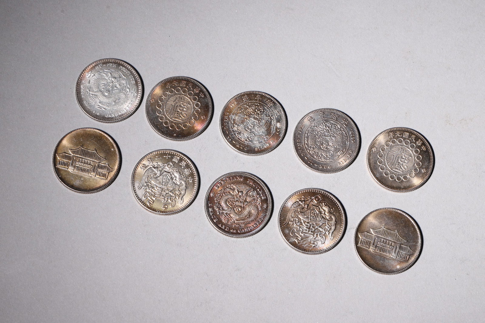 A Group of Ten Silver Coins with Dragon and Building Designs (1 of 9)
