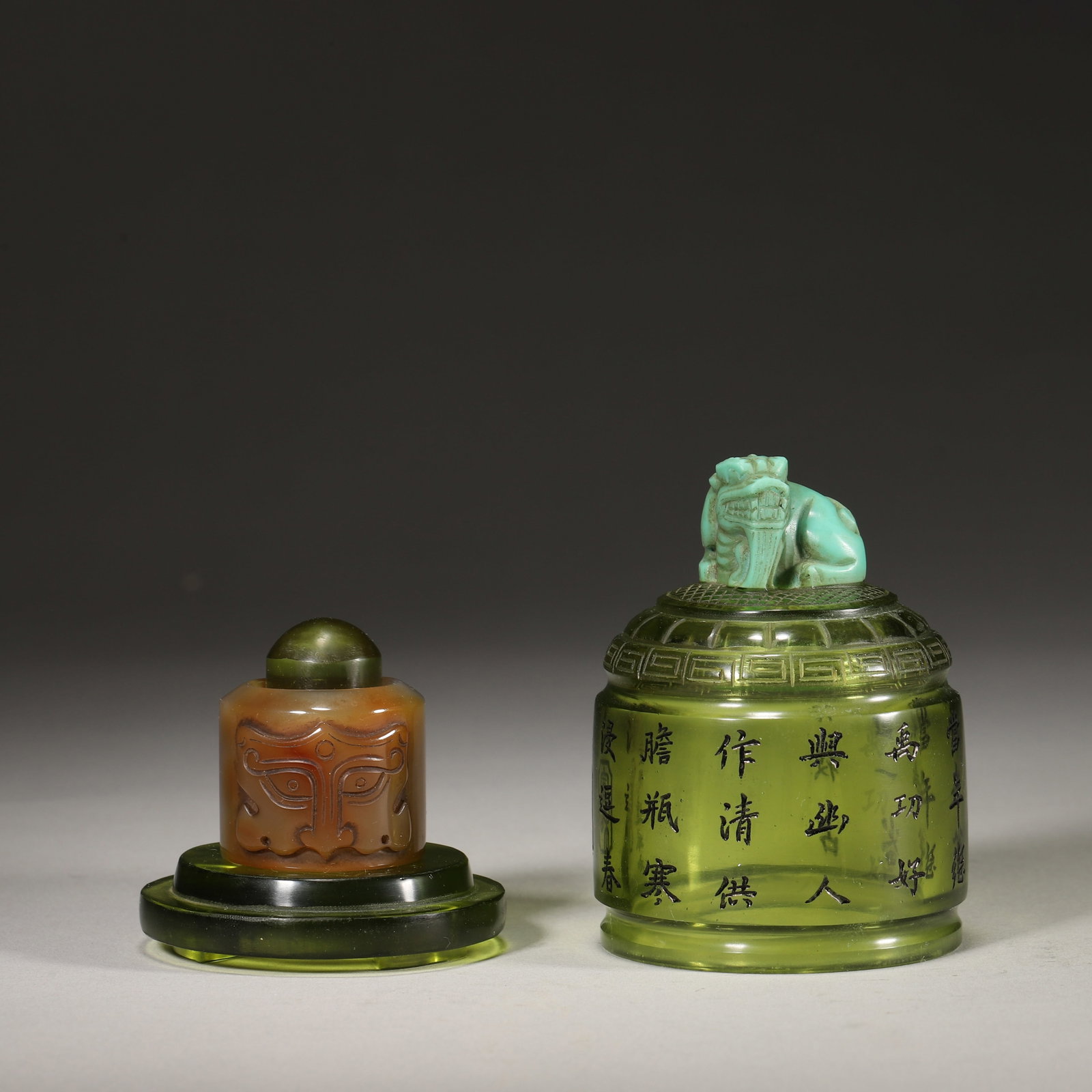 An Agate Beast Mask Archer's Ring and a Green Glass Archer's Ring Case with "Qianlong Nian Zhi: D 5.8cm (2.28 in); H 8.8cm (3.46 in); Inner D 22mm (0.87 in); Wt 29g (0.06 lb); Wt 241g (0.53 lb)A set of Qing Dynasty archer's ring and case, with the ring carved from agate with a beast mask motif, 