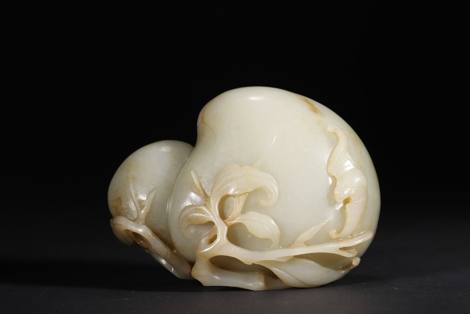 A White Jade 'Bat and Peach' Ornament, Qing Dynasty: 10.4cm x 5.0cm x 8.0cm,556.0g (4.09in x 1.97in x 3.15in,WT 1.2258lb)Carved from fine Hetian white jade with natural russet skin, the double peaches with a bat in relief symbolize longevity and good fo