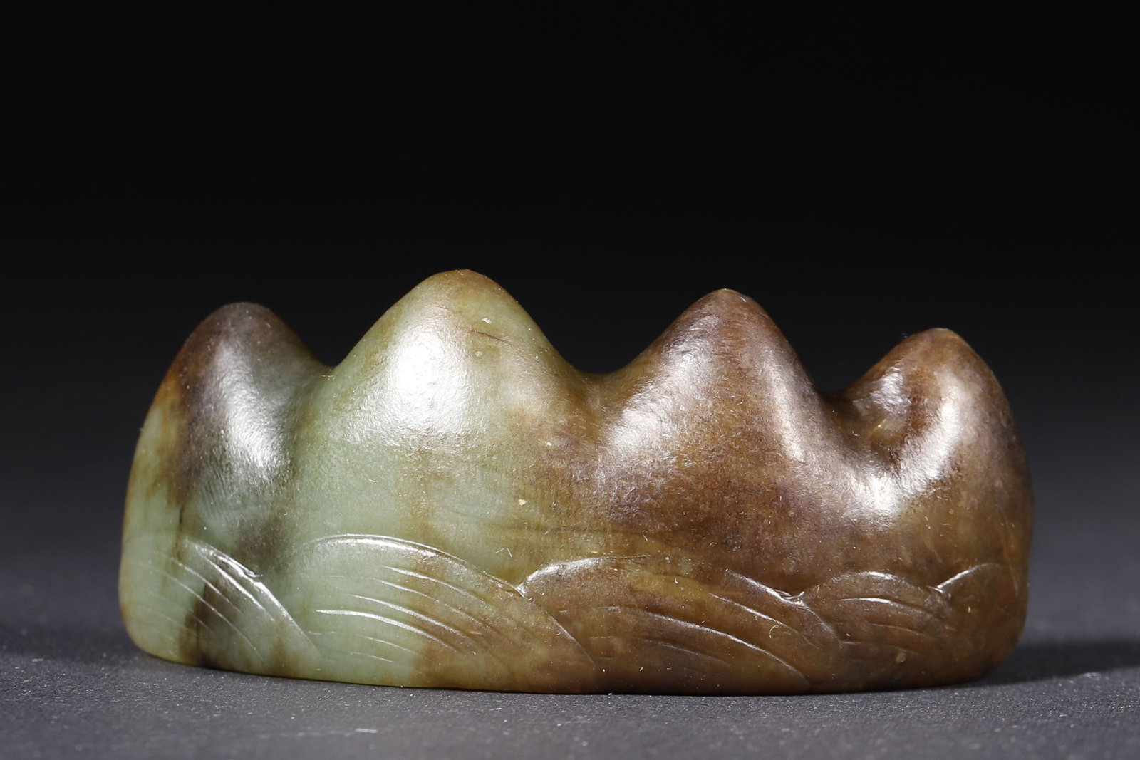 A Green Jade Five-Peak Brush Rest with Wave Carving - Qing Dynasty: 6.6cm x 3.0cm,57.0g (2.6in x 1.18in,WT 0.1257lb)Carved from solid green jade into a five-peak form with wave patterns, it features warm jade texture and rich patina. An elegant Qing Dynasty scholar's 
