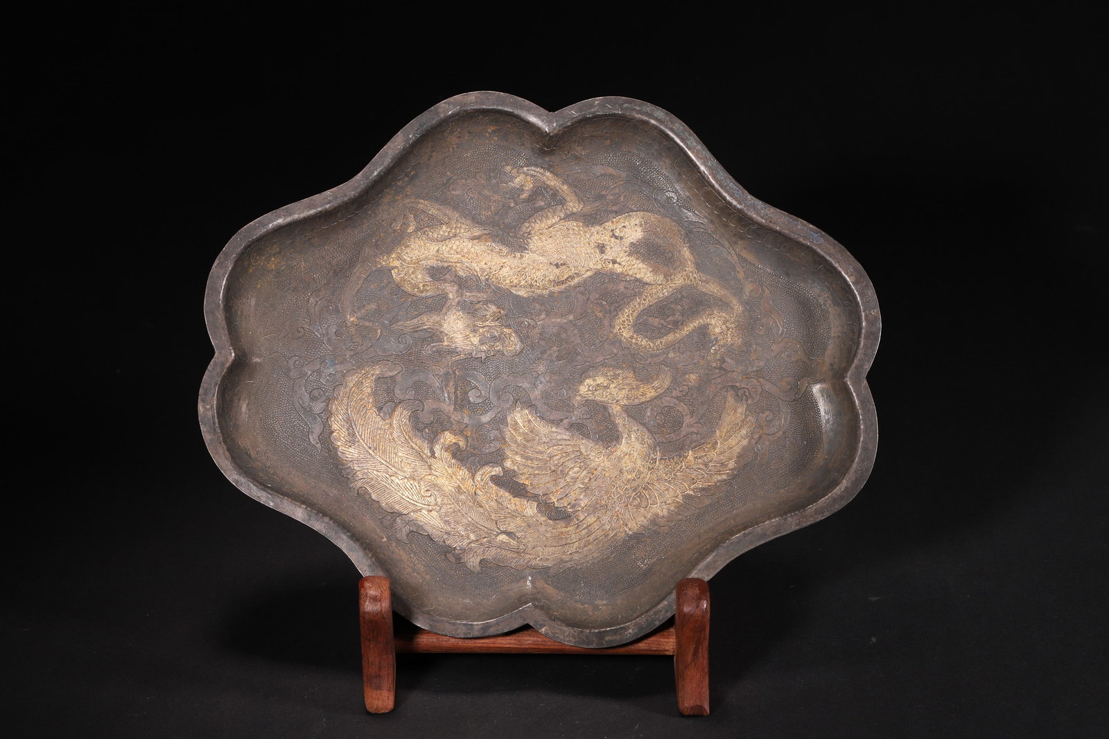 A Tang Dynasty Gilt Silver Flower-Shaped Plate with Engraved Dragon and Phoenix Patterns: Length 21.0cm (8.27in), Width 17.0cm (6.69in), Weight 266.0g (0.59lb)A Tang Dynasty gilt silver flower-shaped plate, crafted with silver and partially gilded. The center is engraved with dragon and ph