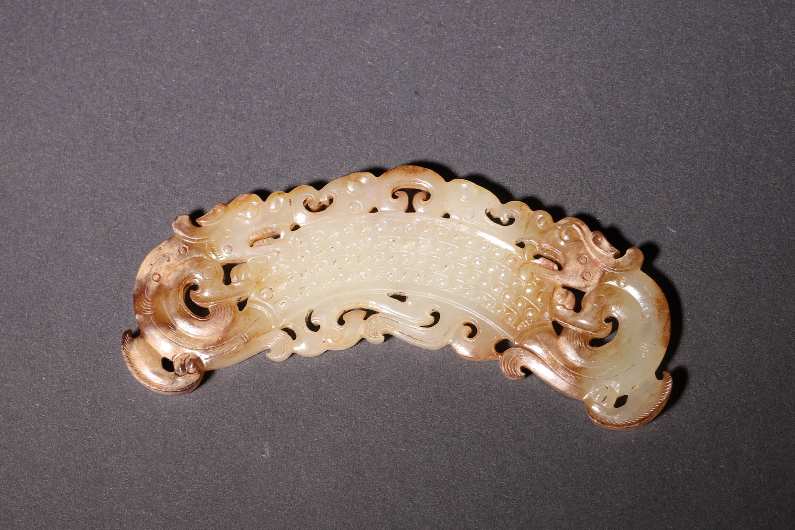 A Warring States Period Hetian Jade Huang with Double Dragon and Grain Pattern: Length 9.3cm (3.66in), Width 4.0cm (1.57in), Weight 30.0g (0.07lb)A Warring States Period Hetian jade huang carved with openwork double dragons and grain patterns. The smooth jade and exquisite crafts