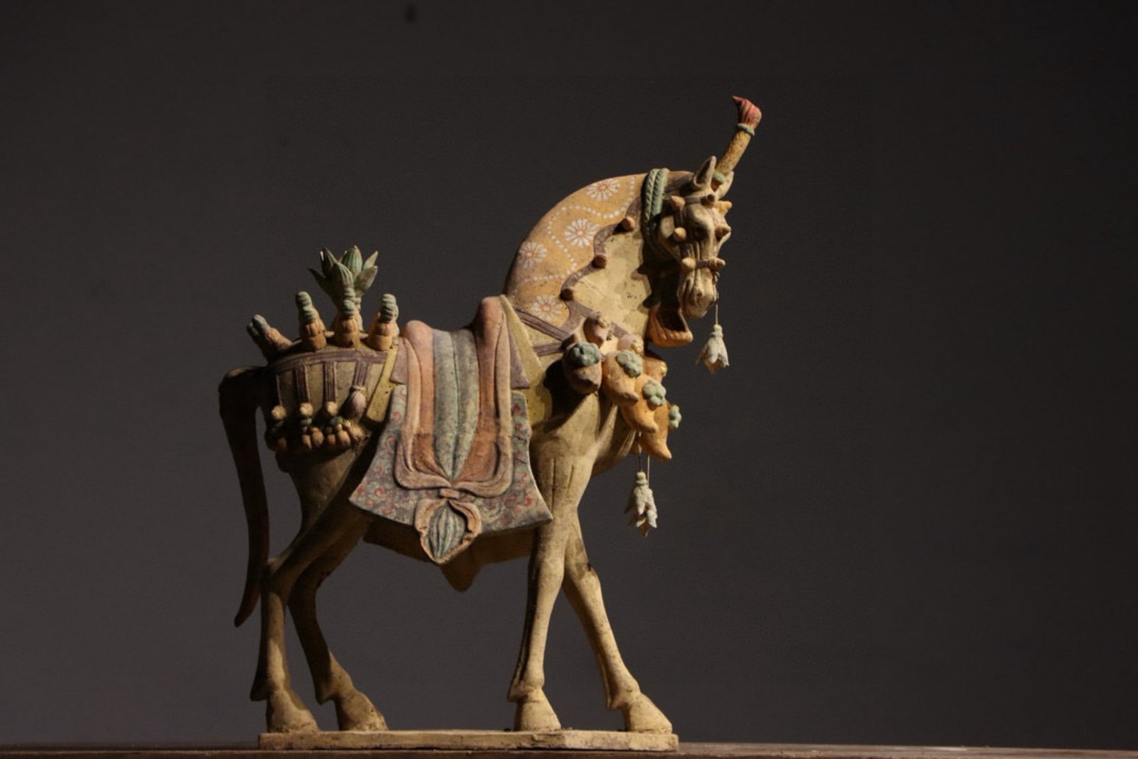 A Painted Pottery Horse Figurine - Tang Dynasty: Length 40cm (15.75 in); Height 58cm (22.83 in)This painted pottery horse figurine dates to the Tang Dynasty. A masterpiece of Tang ceramic art, it features richly decorated saddlery and vibrant colors