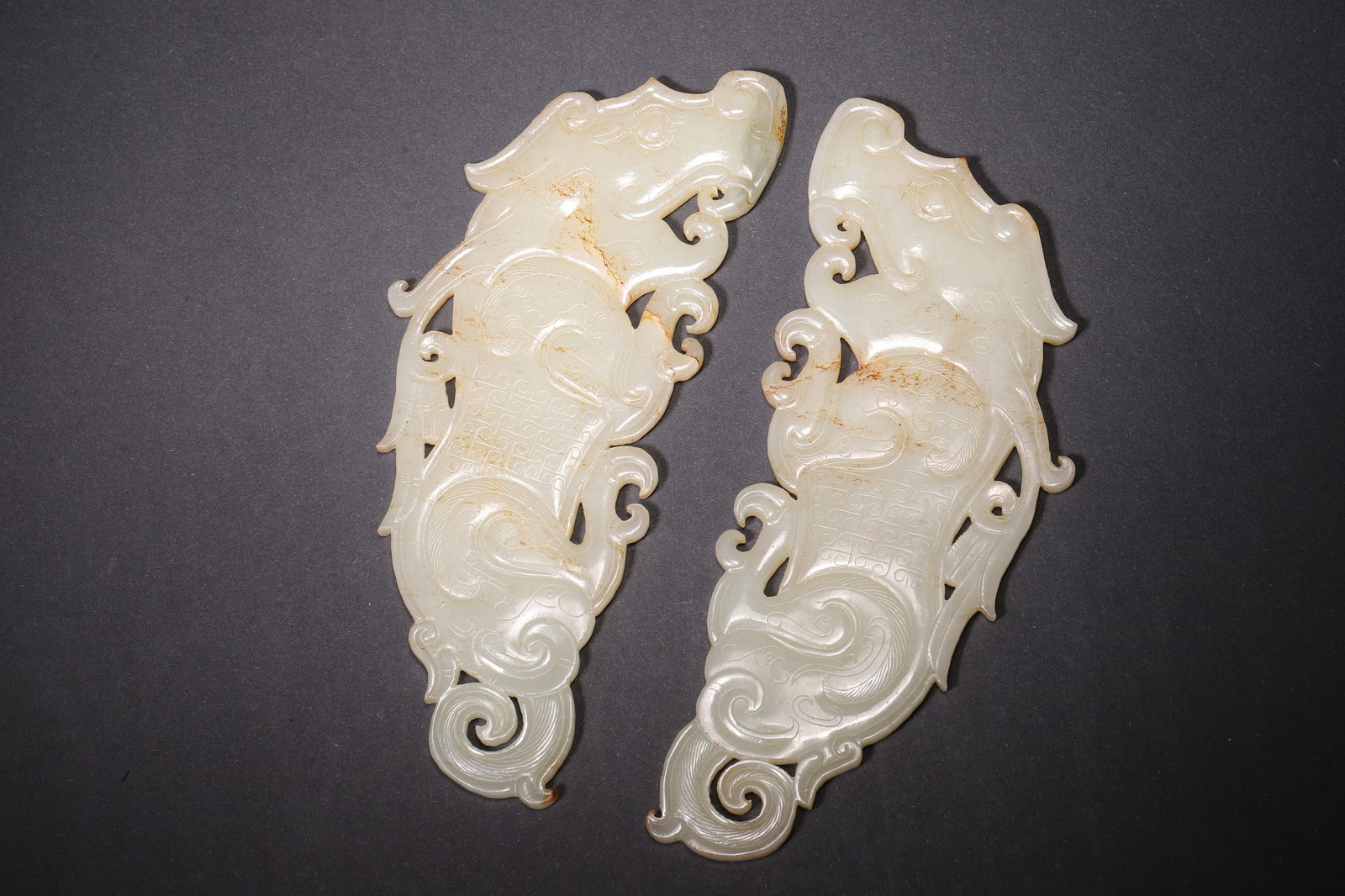 A Pair of Hetian White Jade Auspicious Beast Pendants - Han Dynasty: Length 14.0cm (5.51in), Width 5.5cm (2.17in), Weight 136.0g (0.3lb)This pair of auspicious beast pendants is elaborately carved from Hetian white jade, featuring vivid beasts with smooth flowing lines