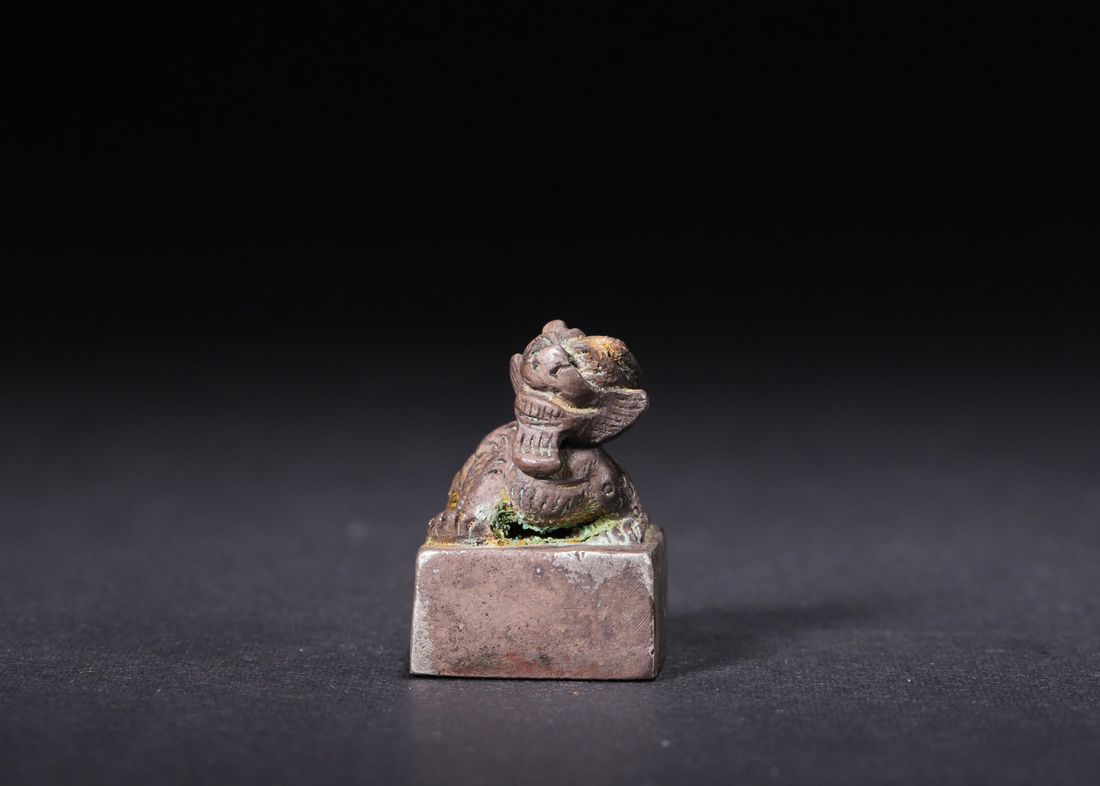 A Silver Square Seal with Auspicious Beast Knob?Han Dynasty: L 1.7cm (0.67 in); W 1.7cm (0.67 in); H 2.5cm (0.98 in); Wt 45g (0.1 lb)A silver square seal from the Han Dynasty, topped with an auspicious beast knob. The high-relief carving features crisp lines an
