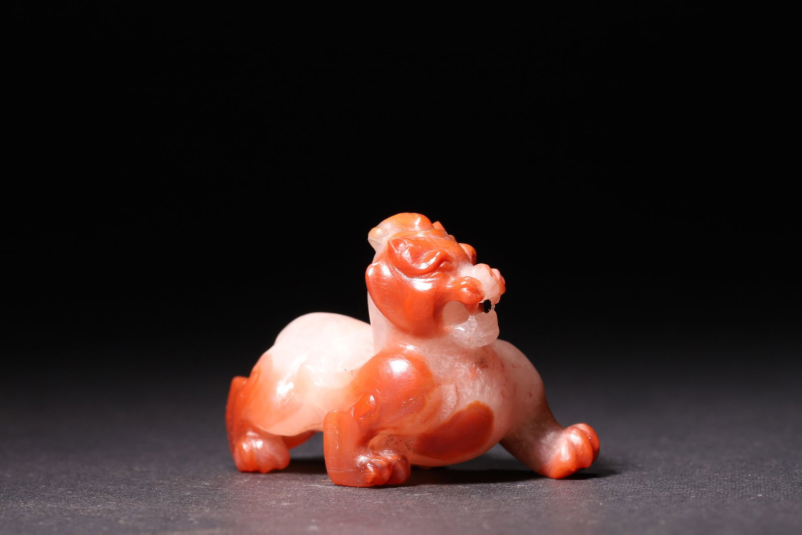 A Han Dynasty Southern Red Agate Auspicious Beast Ornament: Length 5.0cm (1.97in), Width 3.0cm (1.18in), Height 3.4cm (1.34in), Weight 35.0g (0.08lb)A Han Dynasty southern red agate ornament in the form of an auspicious beast, carved in the round. With vivid p