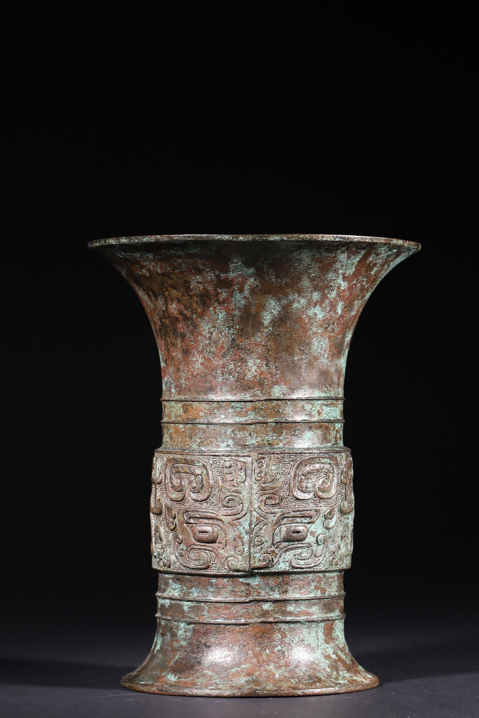 A Bronze Zun Vessel with Taotie Motifs - Late Shang Dynasty: Diameter 16.0cm (6.3in), Height 21.5cm (8.46in), Weight 1005.0g (2.22lb)This bronze zun is a classic ritual wine vessel of the Late Shang Dynasty, with elegant shape, wide mouth and foot, decorated wi