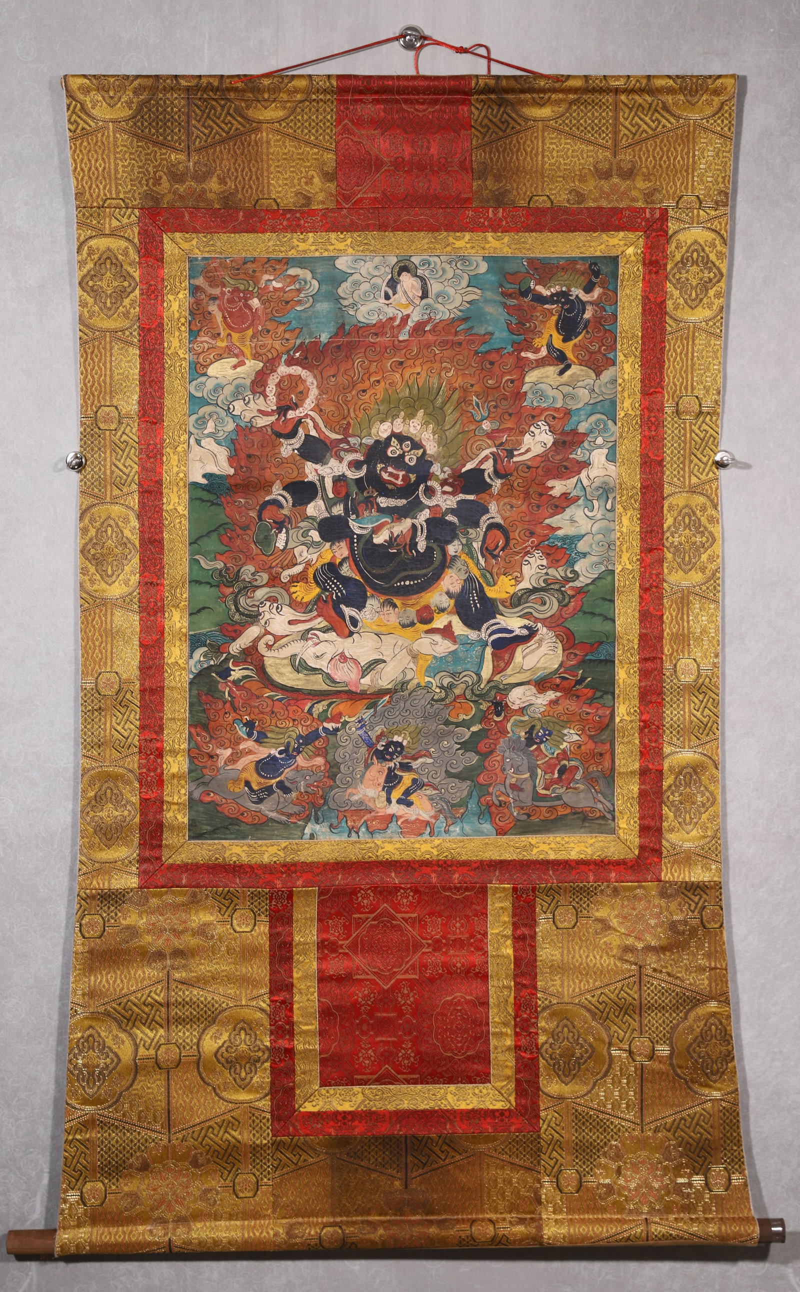 A Six-armed Mahakala Thangka - Qing Dynasty: Length 73.0cm (28.74in), Width 54.0cm (21.26in)This Qing Dynasty thangka depicts Six-armed Mahakala, painted with mineral pigments on cotton. The wrathful protector stands amid flames, surrounded by a