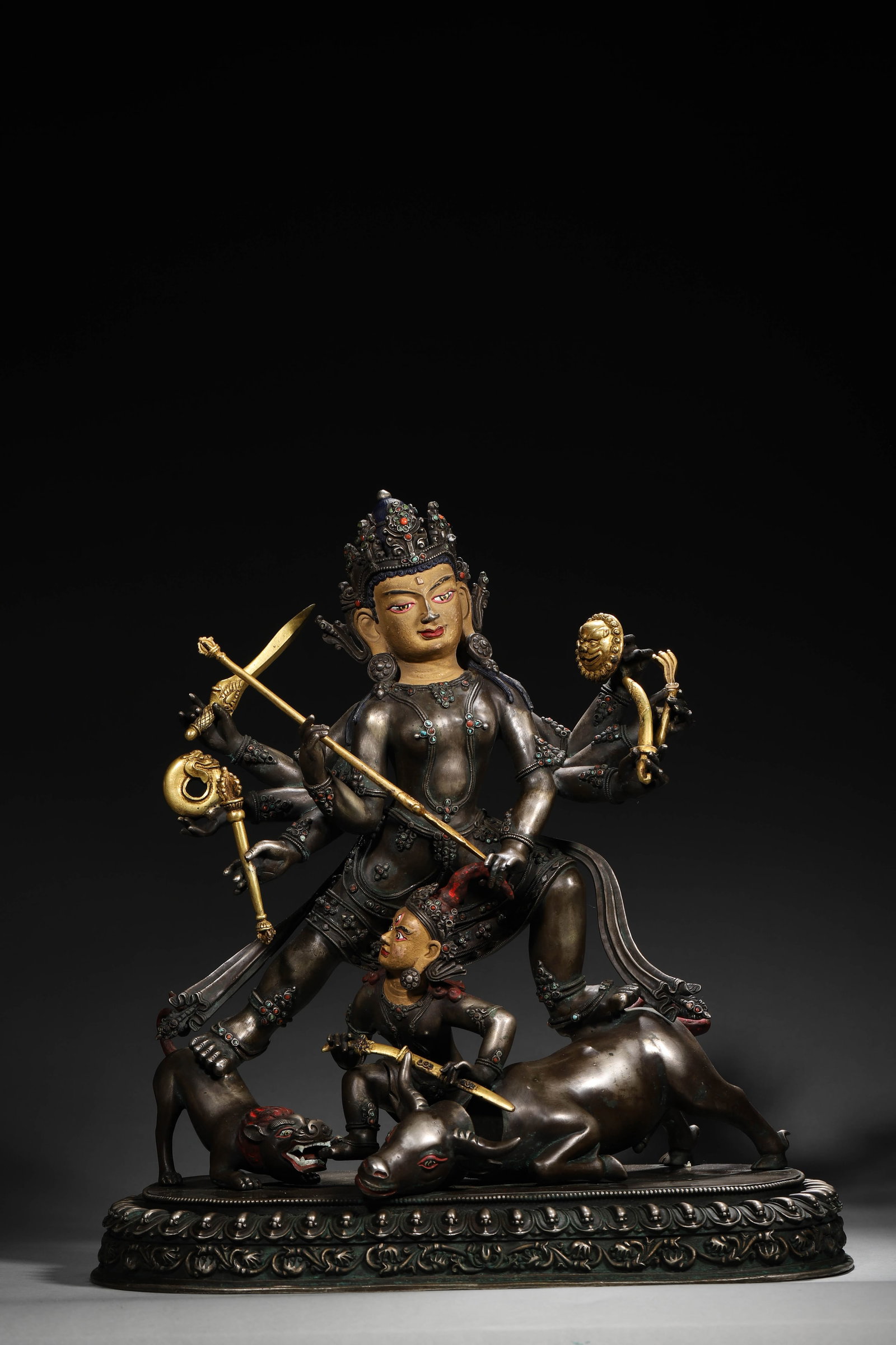 A Tibetan Silver Gem-Inlaid and Gold-Gilded Statue of the Great Adept Consort, Qing Dynasty: L 36cm (14.17 in); W 18cm (7.09 in); H 39cm (15.35 in); Wt 10.58kg (23.32 lb)A Qing Dynasty Tibetan silver statue of the Great Adept Consort, with gem inlays and gilt accents, holding implements and s
