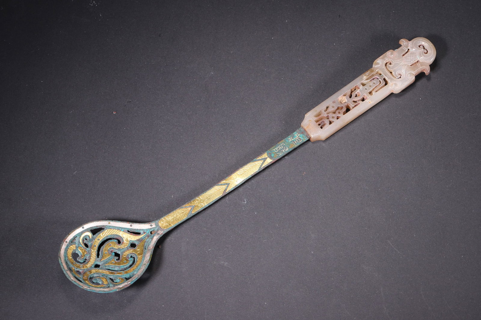 A Warring States Bronze Spoon with Gold and Silver Inlay and Jade Handle: Length 24.5cm (9.65in), Width 4.5cm (1.77in), Weight 79.0g (0.17lb)This Warring States bronze spoon features a jade handle with openwork dragon patterns and exquisite gold and silver inlay. It embodie