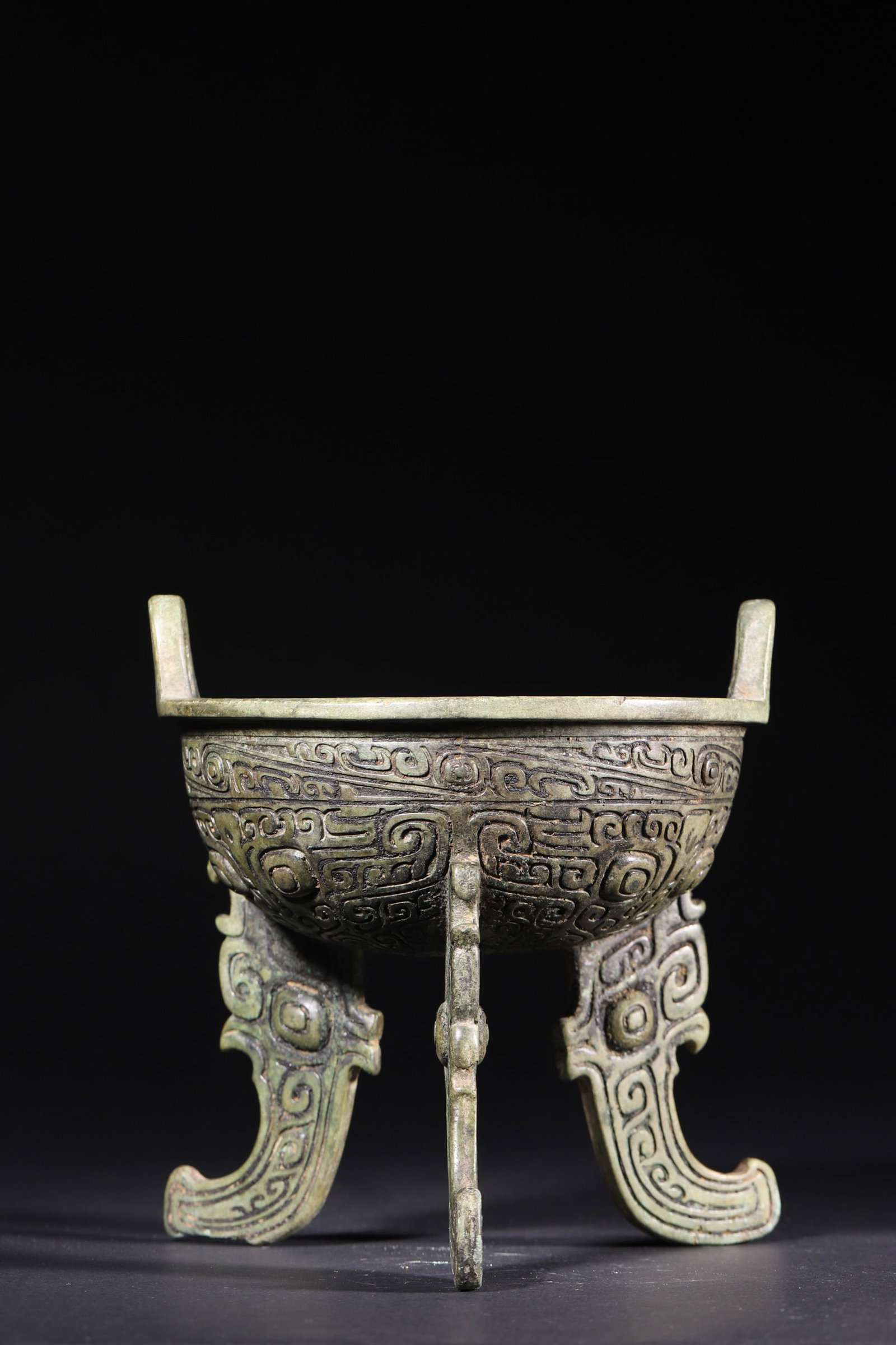 A Bronze Ding with Taotie Motifs and Flat Legs - Late Shang Dynasty: Diameter 16.0cm (6.3in), Height 17.0cm (6.69in), Weight 1379.0g (3.04lb)This bronze ding is a classic ritual vessel of the Late Shang Dynasty, featuring upright ears, round belly and three phoenix-sha