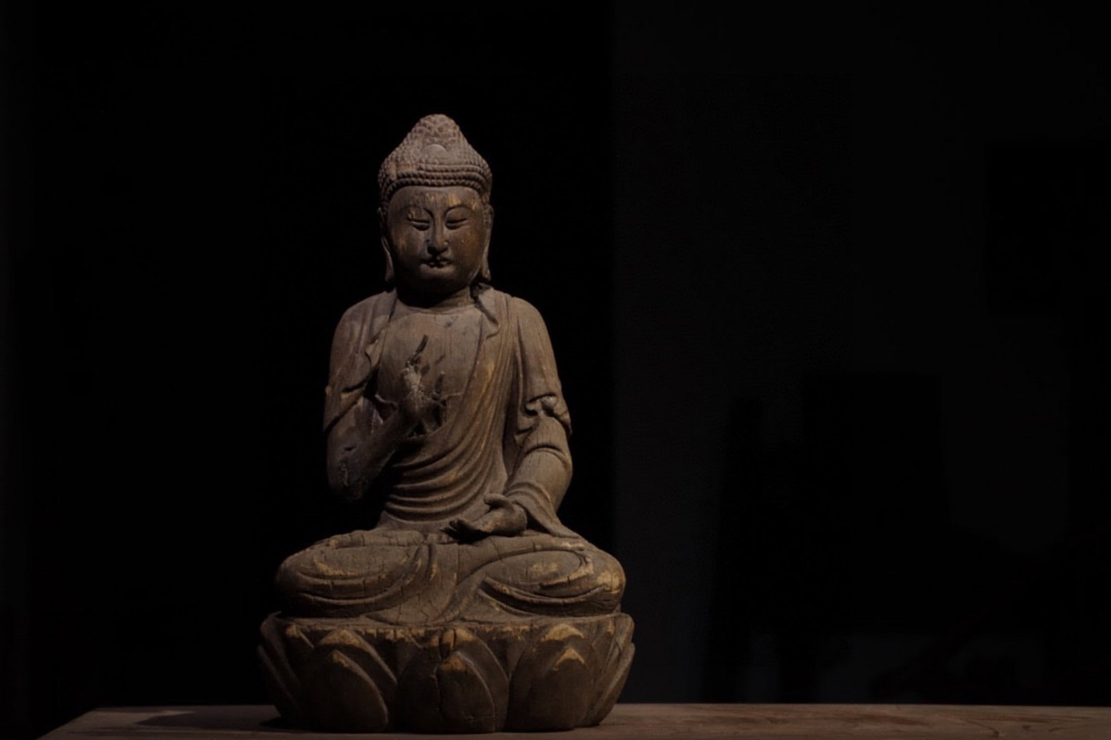 A Wood Carved Figure of Sakyamuni - Ming Dynasty: Height 45cm (17.72 in)This wood carved figure of Sakyamuni dates to the Ming Dynasty. The Buddha sits serenely on a lotus pedestal, with simple yet elegant robes and a calm expression, embodying the s