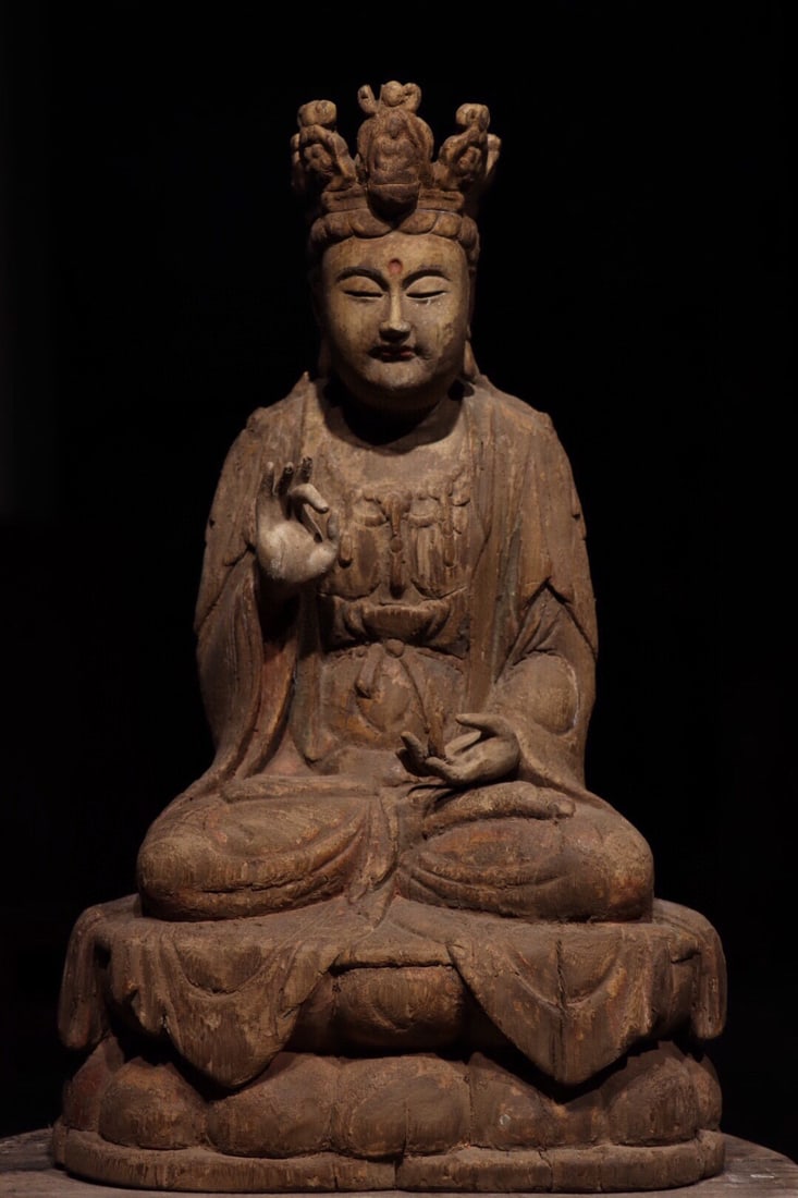 A Painted Wood Figure of Guanyin - Ming Dynasty: Height 47cm (18.5 in); Width 28cm (11.02 in)This painted wood figure of Guanyin dates to the Ming Dynasty. The serene Bodhisattva sits in meditation, adorned with flowing robes and faded polychromy, e