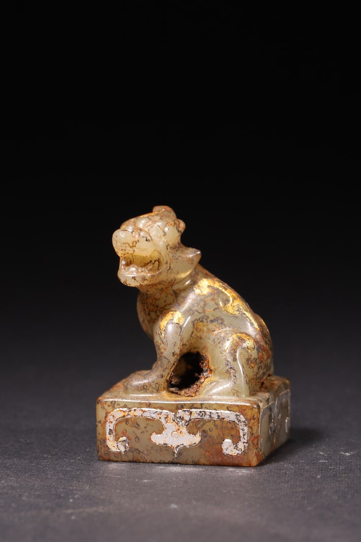 A Han Dynasty Hetian Jade Seal with Gold/Silver Inlay and Auspicious Beast Knob: Length 2.7cm (1.06in), Width 2.7cm (1.06in), Height 4.0cm (1.57in), Weight 41.0g (0.09lb)A Han Dynasty Hetian jade seal with an auspicious beast knob, decorated with gold and silver inlay. With natura