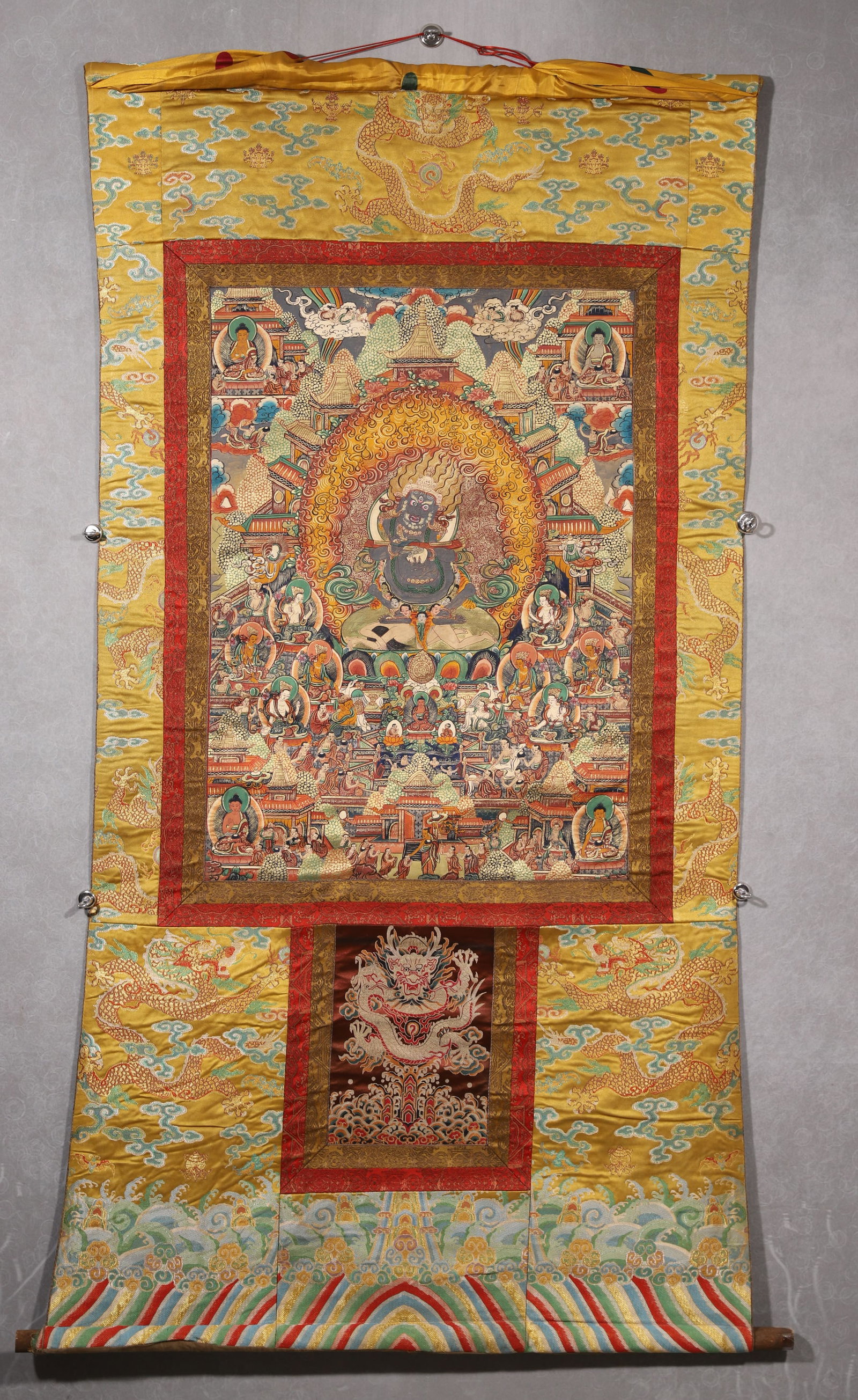 A Black-cloaked Mahakala Thangka - Qing Dynasty: Length 80.0cm (31.5in), Width 58.0cm (22.83in)This Qing Dynasty thangka depicts Black-cloaked Mahakala, painted with mineral pigments on cotton. The central wrathful protector stands amid flames, surr