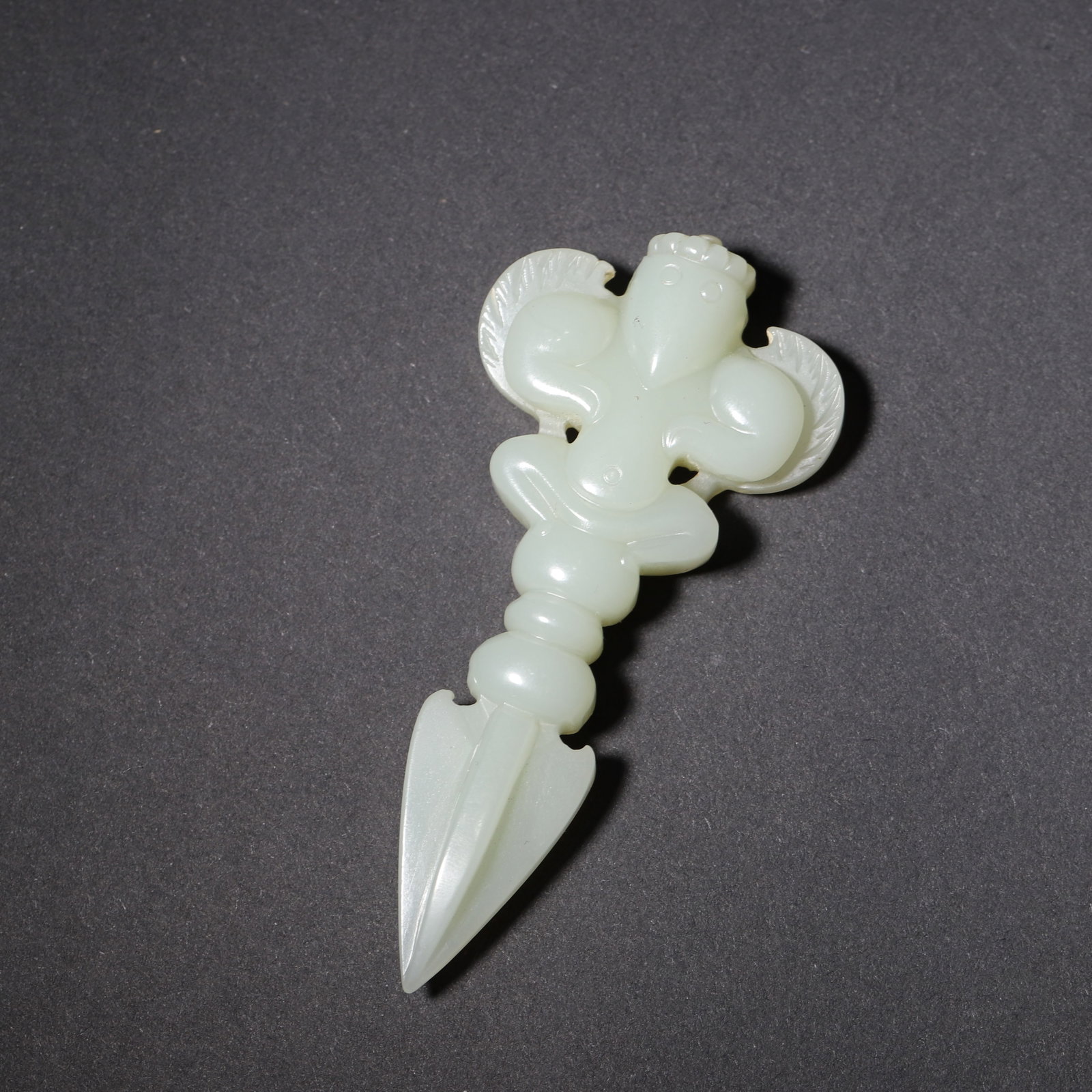 A Hetian Jade Garuda Vajra Pestle, Qing Dynasty: 7.7cm x 3.6cm,26.0g (3.03in x 1.42in,WT 0.0573lb)A fine Hetian jade vajra pestle, Qing Dynasty, finely carved with a Garuda (golden-winged bird) at the top. The bird features rounded, plump form with 