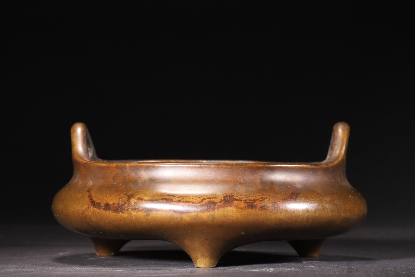 A Qing Dynasty Bronze Incense Burner with Three Legs and Upright Handles: Diameter 17.0cm (6.69in), Height 7.0cm (2.76in), Weight 1323.0g (2.92lb)This Qing Dynasty bronze incense burner features a rounded body with upright handles and three legs. The base bears the seal scr