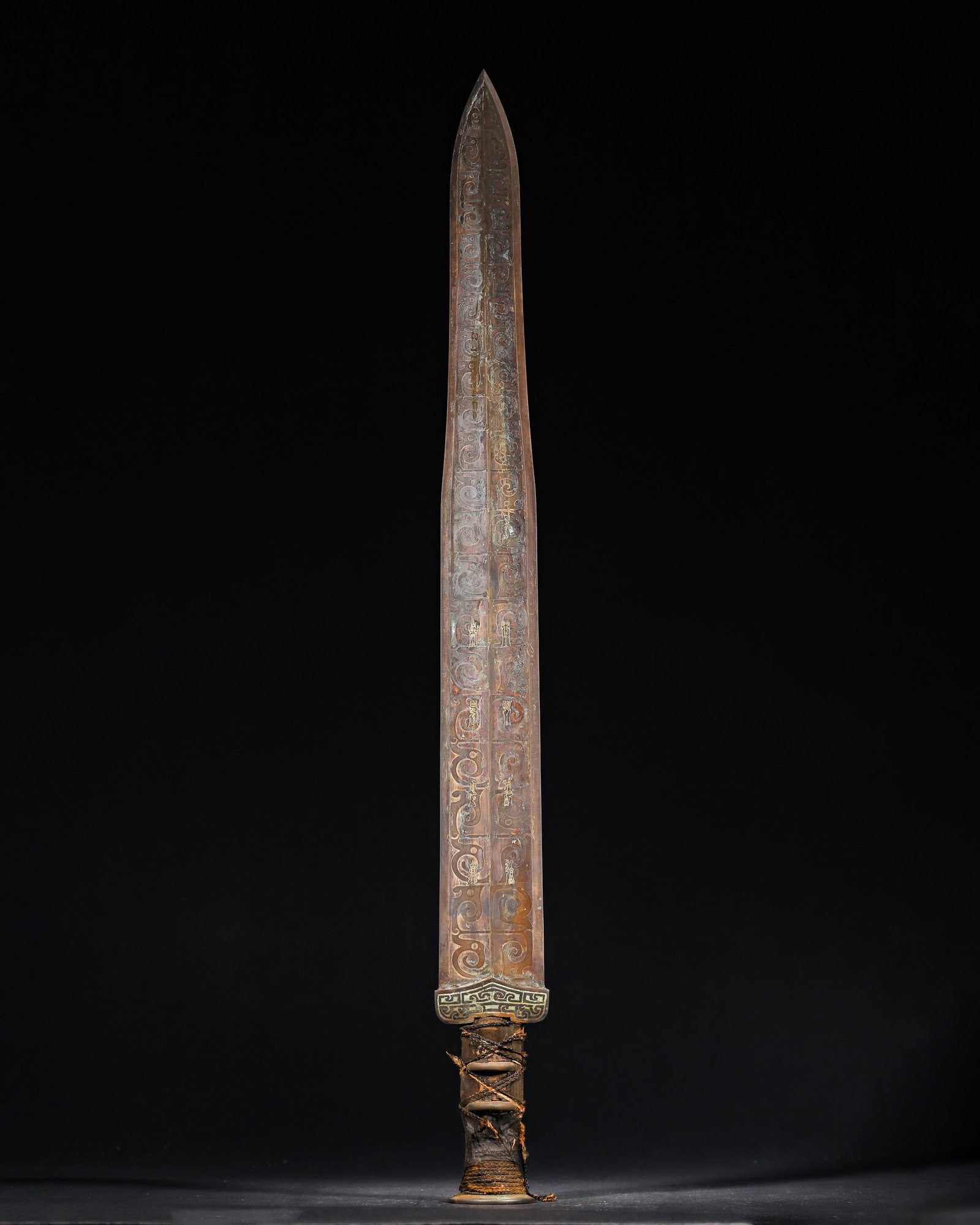 A Bronze ornament with Silver-Inlaid Bird-Script and Dragon Pattern, Warring States Period: 1171.0 g (2.58 lb) | 60.0 x 6.0 cm (23.62 x 2.36 in)This Warring States bronze ornament features a long, sharp blade fully decorated with silver-inlaid dragon patterns, with clear silver-inlaid bird-s