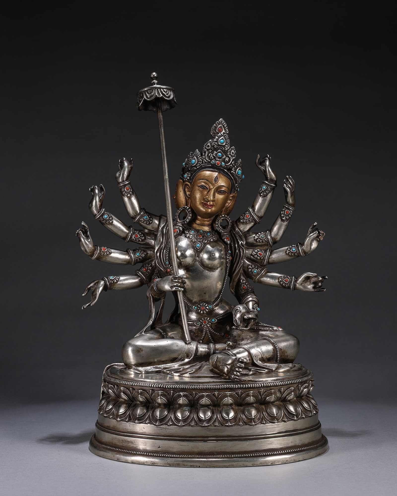 A Silver Statue of Sit?tapatr? with Gem Inlays, Qing Dynasty: L 22cm (8.66 in); W 15cm (5.91 in); H 32cm (12.6 in); Wt 4.91kg (10.82 lb)A Qing Dynasty silver statue of Sit?tapatr? with gem inlays and gilt face, holding various implements including the white umbr