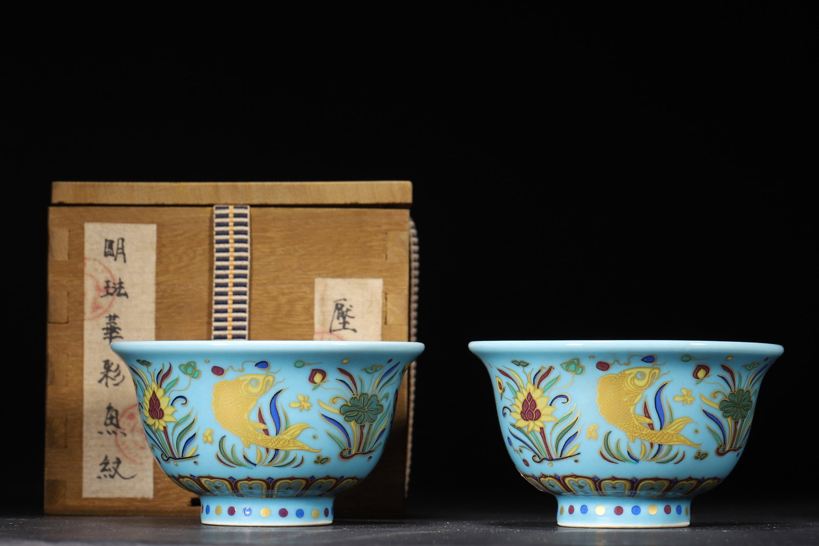 A Pair of Ming Xuande Blue-Ground Fahua Glazed Fish-Algae Cups: 9.5 x 9.5 x 5.5 cm (D x D x H = 3.74 x 3.74 x 2.17 in)This is a pair of Ming Xuande blue-ground Fahua glazed fish-algae cups. With sky-blue glaze, gold outlines, vivid fish, aquatic plants and flower 
