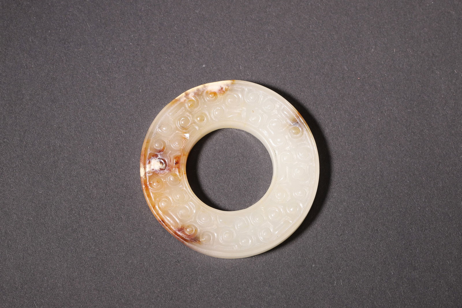 A Hetian Jade Bi with Curved Cloud Pattern - Han Dynasty: Diameter 4.6cm (1.81in), Weight 18.0g (0.04lb)This Han Dynasty jade bi is finely carved from premium Hetian jade with natural aged patina. It features regular round shape and delicate curved cloud pat