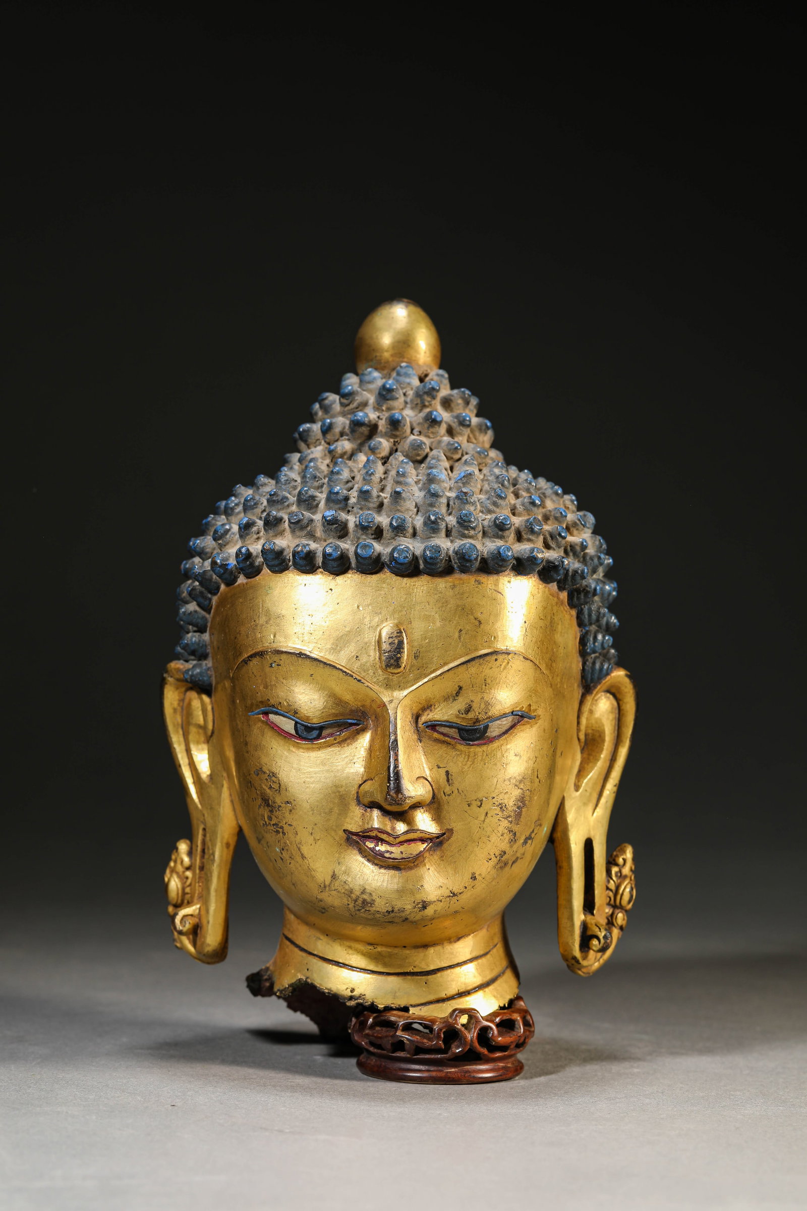 A Gilt-Bronze Head of Buddha: Dimensions: Weight: 2547g. Length: 12.6 cm (4.96 in) x Width: 11.0 cm (4.33 in) x Height: 20.1 cm (7.91 in). All measurements are approximate.
