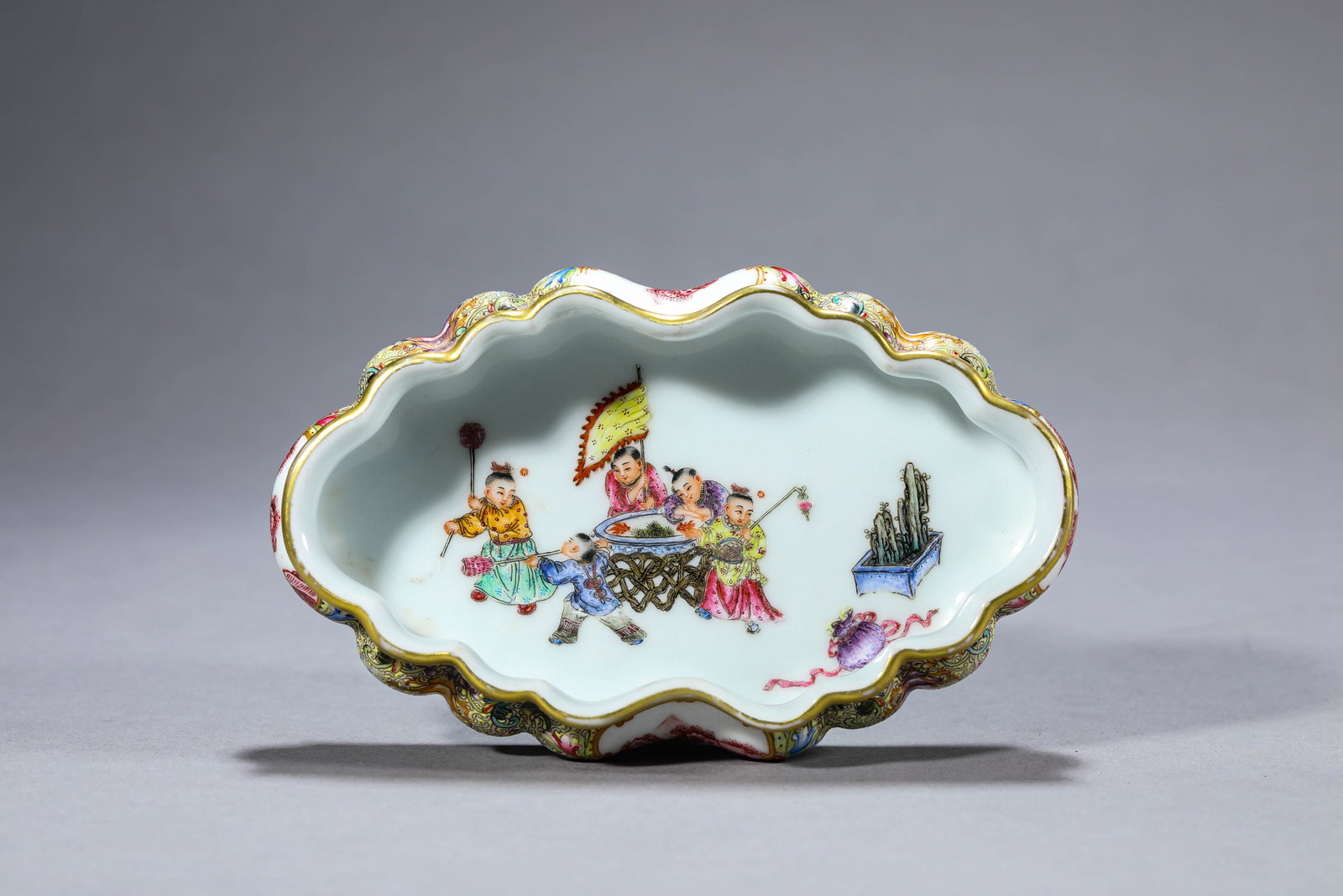 A Famille-Rose 'Landscape and Children at Play Reserves' Brush Washer: Dimensions: Length: 15.1 cm (5.94 in) x Width: 9.3 cm (3.66 in) x Height: 3.1 cm (1.22 in). All measurements are approximate.