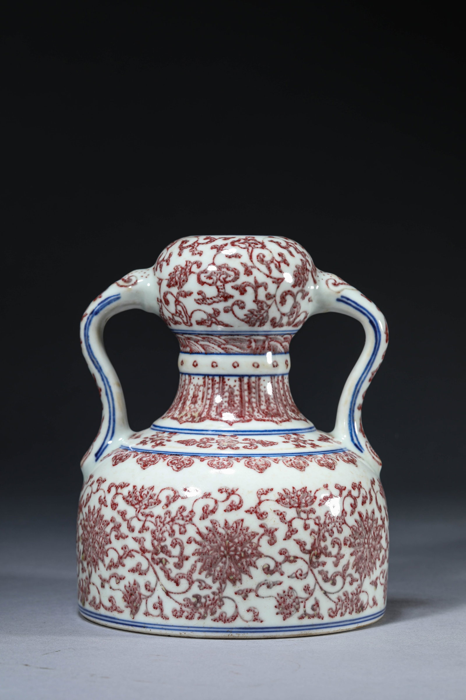 A Blue and White and Underglaze-Red 'Interlocking Florals' 'Ruyi Handles' Zun: Dimensions: Width: 14.5 cm (5.71 in) x Height: 18.0 cm (7.09 in). All measurements are approximate.