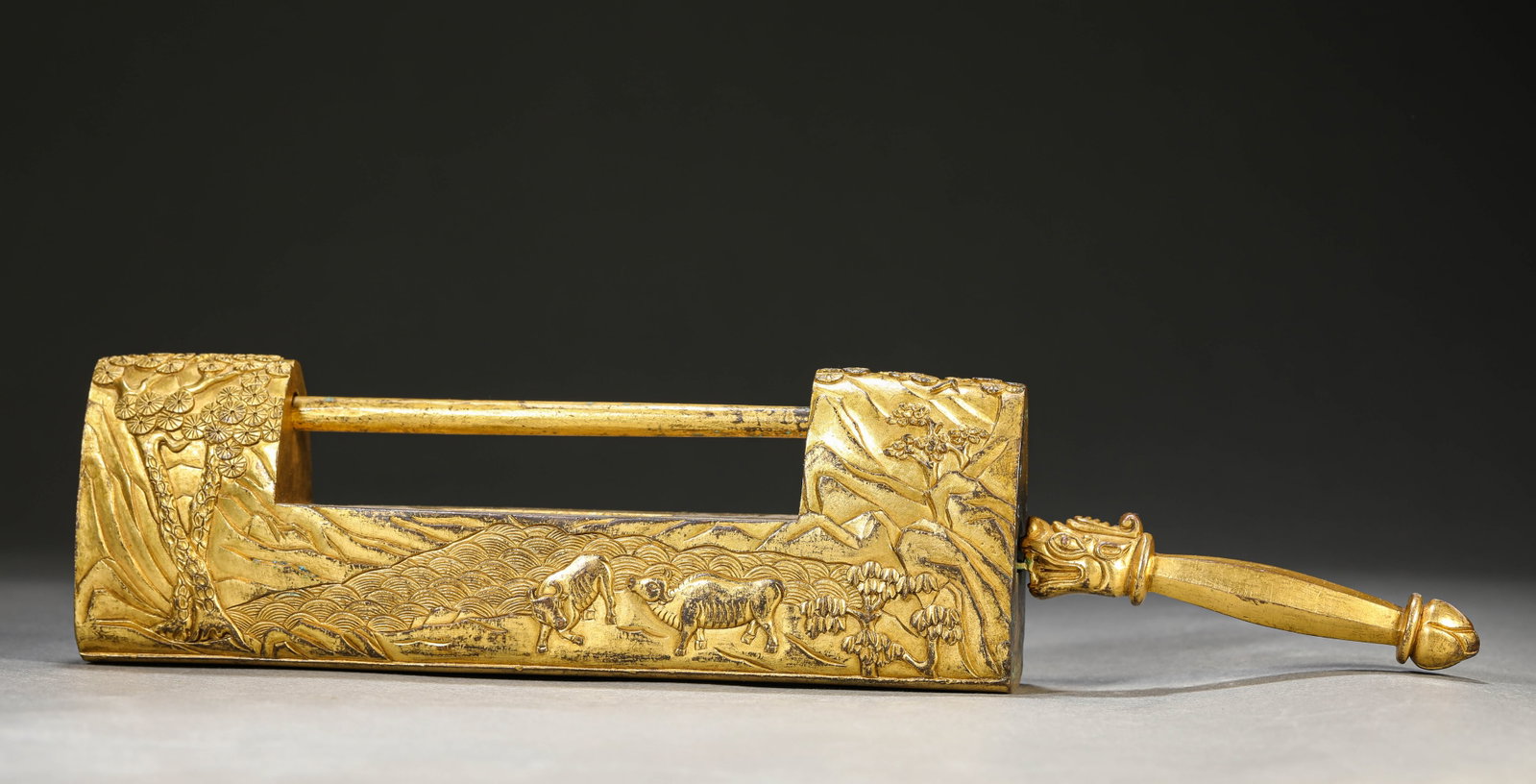 A Gilt-Bronze ??Ox Ploughing?? Padlock: Dimensions: Weight: 1843g. Length: 32.0 cm (12.60 in) x Width: 4.2 cm (1.65 in) x Height: 7.0 cm (2.76 in). All measurements are approximate.