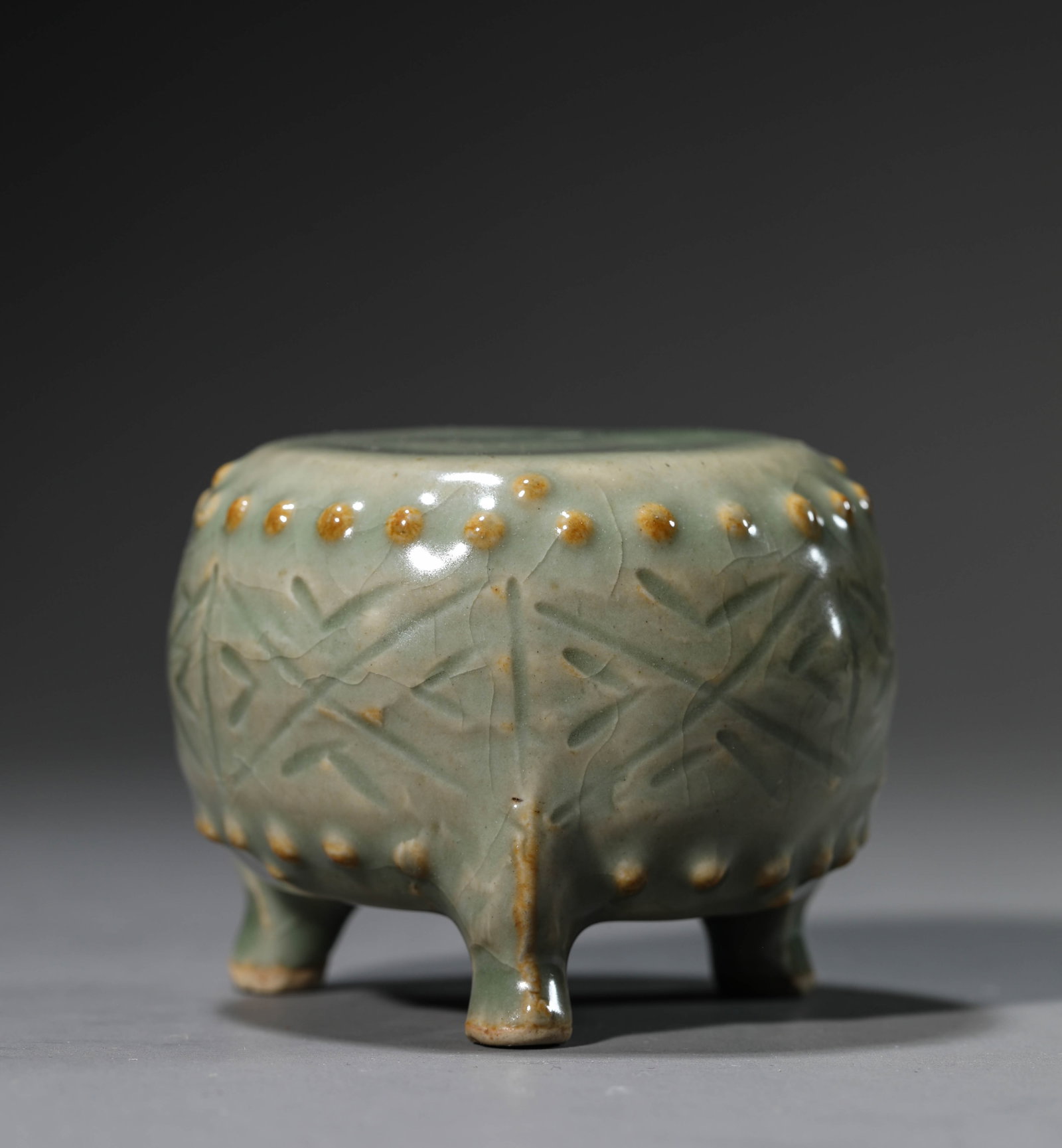 A Celadon-Glazed Ornament: Dimensions: Width: 7.0 cm (2.76 in) x Height: 5.0 cm (1.97 in). All measurements are approximate.