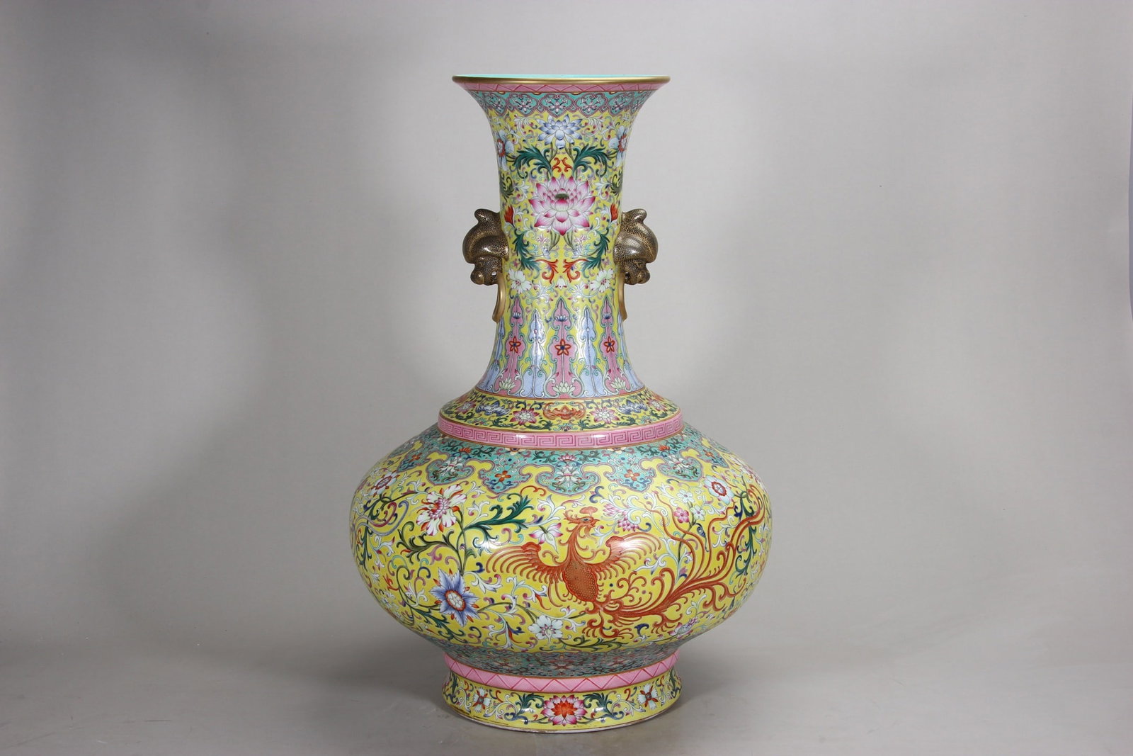 A Large Yellow-Ground Foreign Enamel Phoenix Vase with Double Handles, Qianlong Period, Qing Dynasty: H 61.5cm (24.21 in)This Qianlong period large vase features a magnificent form. Covered in yellow-ground foreign enamel with vivid phoenix and flower patterns, it has elephant-head handles and turquoi