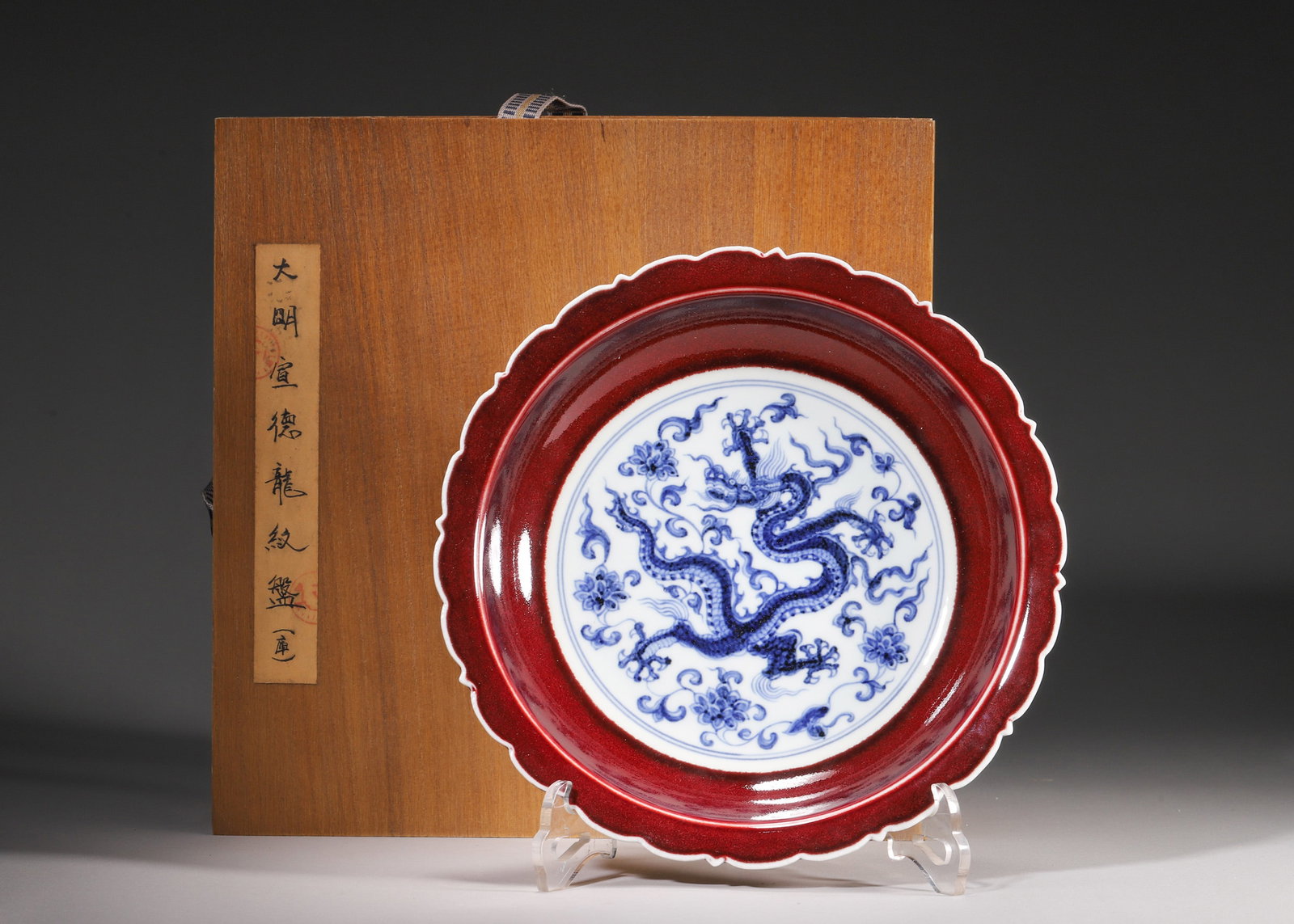 A Ming Xuande Ruby Red-Glazed Blue and White Dragon Dish, Ming Dynasty: D 22.0cm (8.66 in); H 5.0cm (1.97 in)A Ming Xuande period dish with a flower-shaped rim. It is glazed with ruby red outside and painted with blue and white dragon inside. The dragon is powerful, and t
