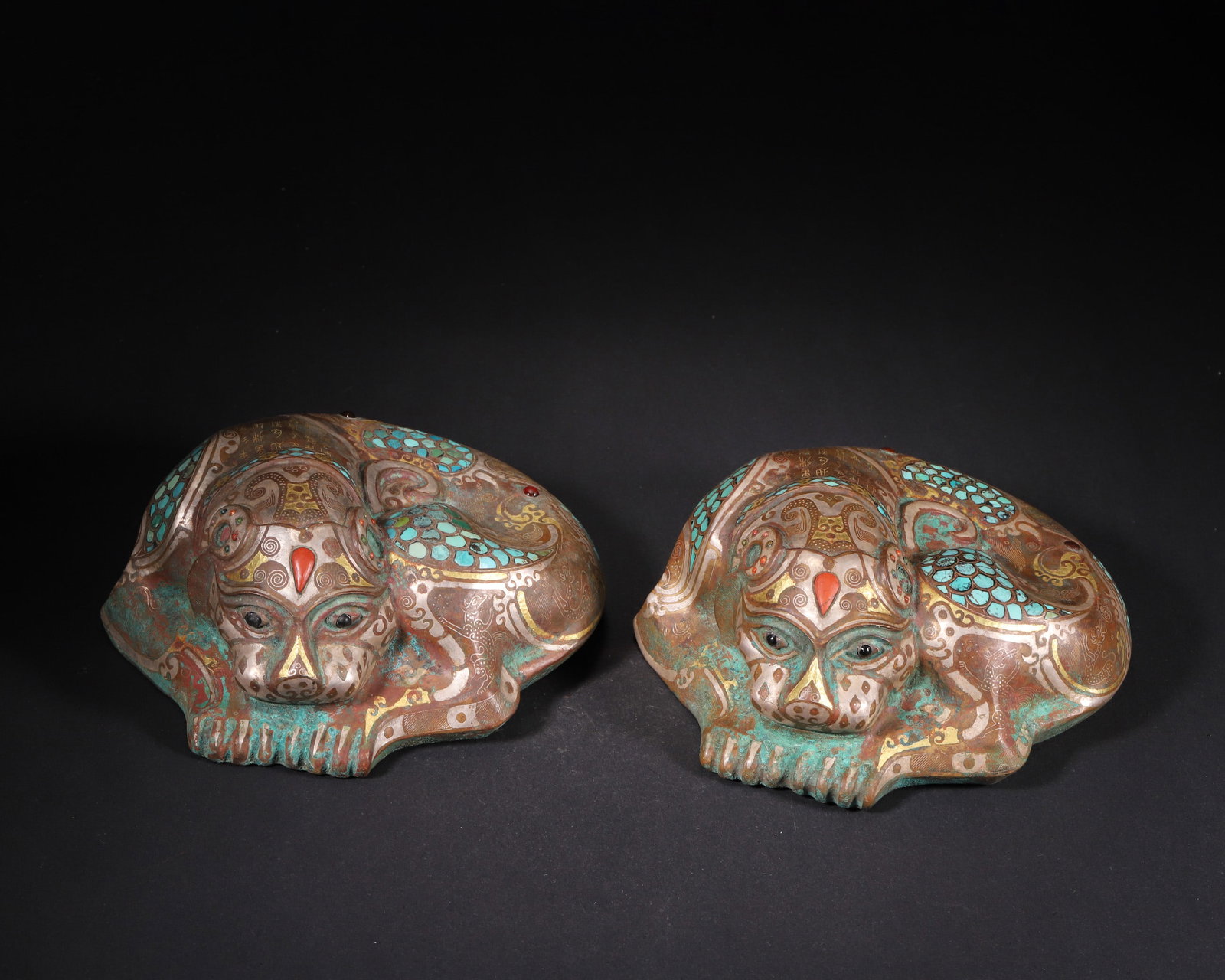 A Pair of Gold and Silver Inlaid Bronze Auspicious Beast Stands with Turquoise Inlays, Warring: L 15.0cm (5.91 in); W 12.0cm (4.72 in); H 6.5cm (2.56 in); Wt 1476.0g (3.25 lb)A pair of Warring States Period bronze beast-shaped stands, exquisitely inlaid with gold, silver, turquoise and agate. Fe