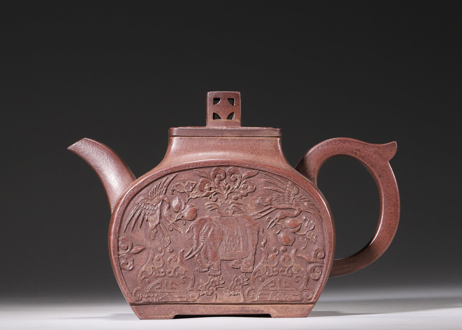 A Square Zisha Teapot with Peace Elephant Pattern, Qing Dynasty: L 17cm (6.69 in); W 7.5cm (2.95 in); H 11.5cm (4.53 in)This is a square Zisha teapot of Qing Dynasty. It has solid clay body and elegant relief patterns symbolizing peace and good fortune. Exquisite c
