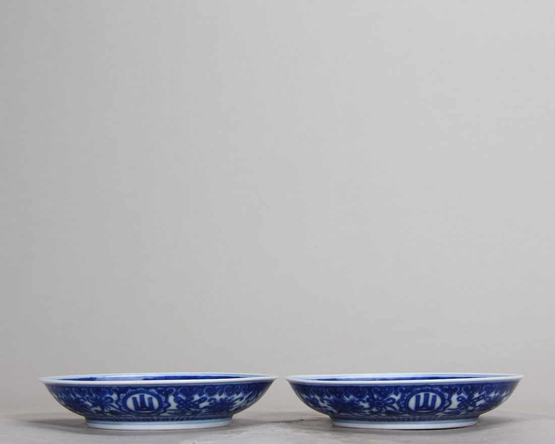 A Pair of Blue and White Dishes with Eight Auspicious Symbols and "Shan Gao Shui Chang": D 11.7cm (4.61 in)A pair of Qianlong period blue and white dishes. They are finely potted with smooth white glaze. The exterior features eight auspicious symbols and "Shan Gao Shui Chang" characters, 