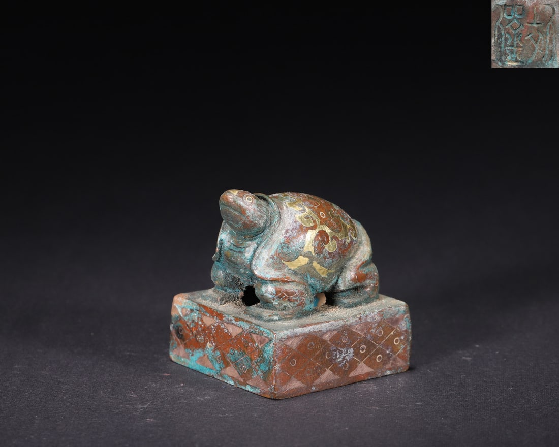 A Gold and Silver Inlaid Bronze Seal with Tortoise Knob, Han Dynasty: L 3.8cm (1.5 in); W 3.8cm (1.5 in); H 4.0cm (1.57 in); Wt 133.0g (0.29 lb)A Han Dynasty bronze seal with a tortoise knob, inlaid with gold and silver. Features cloud patterns on the knob, geometric de