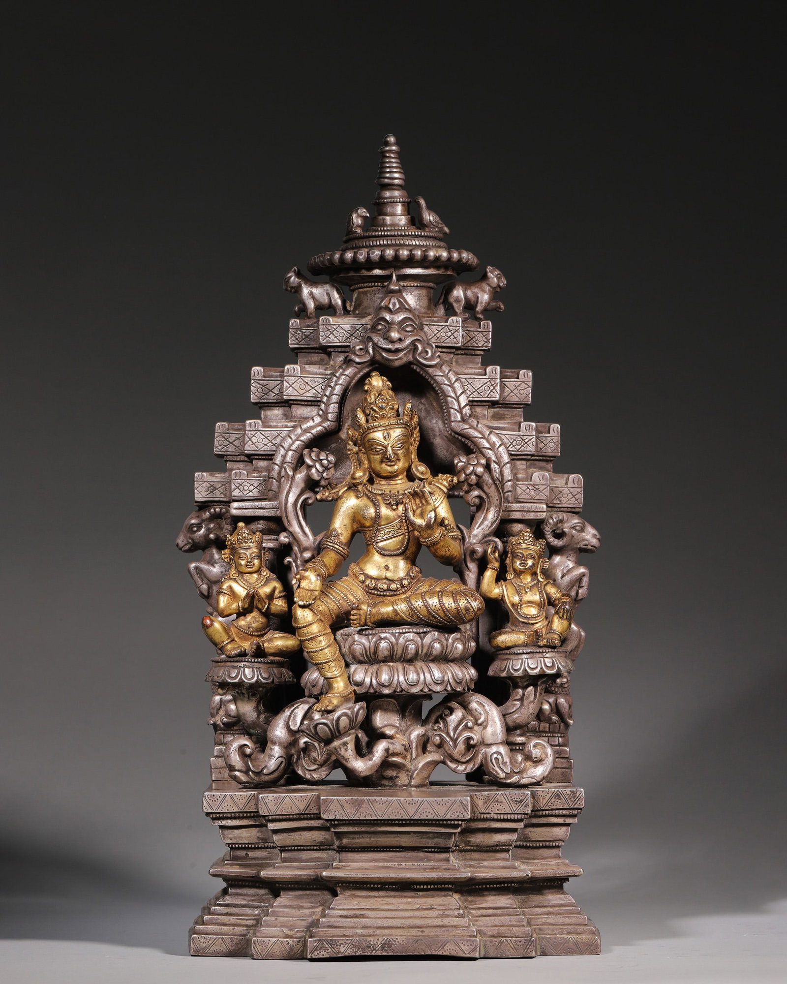A Gilt-Bronze Figure of Tara with Silver Shrine, Qing Dynasty: H 42cm (16.54 in); L 21cm (8.27 in); W 12.5cm (4.92 in); Wt 7548g (16.64 lb)A Qing Dynasty gilt-bronze figure of Tara with a silver shrine. The seated Tara features delicate gilt details and a serene 