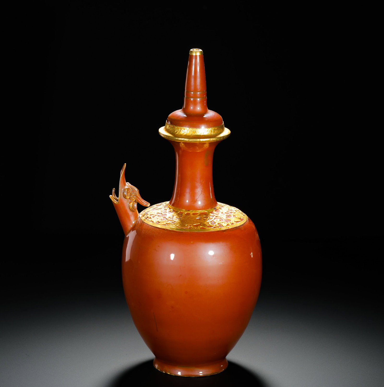 SONG DYNASTY RED GLAZED PHOENIX-HEADED VASE: Height:32cm(12.60in) Width:16cm(6.30in) Weight:840g(1.85lb)Persimmon-red glazed Buddhist kundika phoenix spout vase with gilt carved mount, Song Dynasty. Fully covered in glossy even reddish-brown