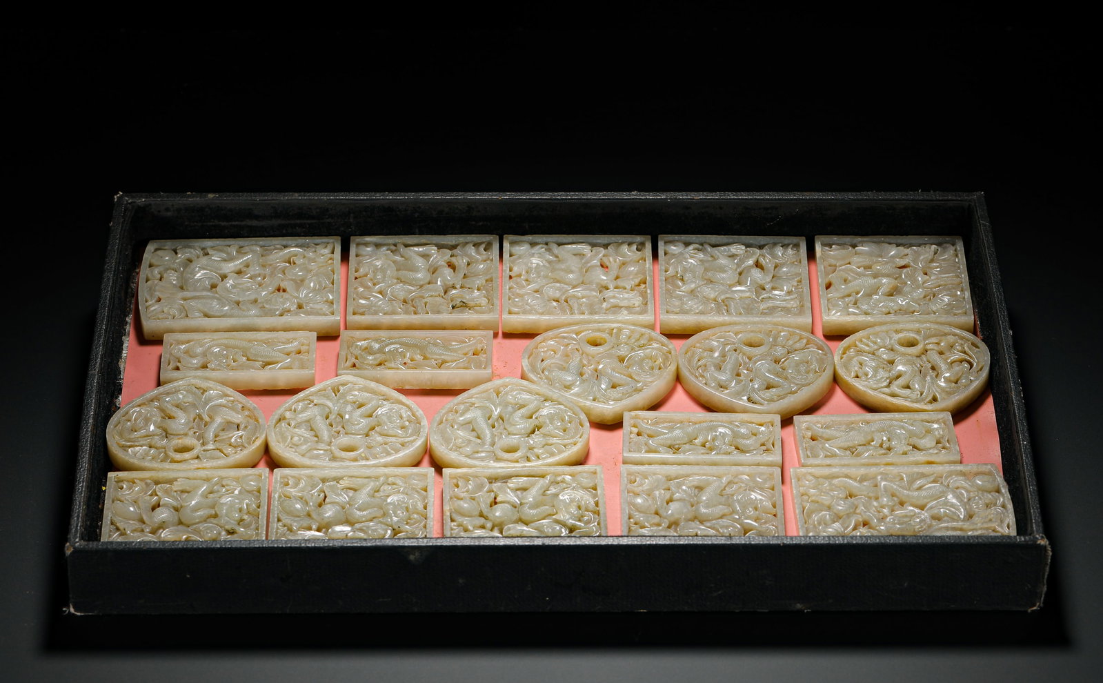 HETIAN WHITE JADE PIERCED DRAGON PATTERN JADE BELT PLATE OF THE QING DYNASTY: Height:8cm(3.15in) Width:6cm(2.36in) Weight:1330g(2.93lb)Complete set of seventeen white jade belt plaques carved with hollowed double dragon patterns, stored in original old brocade box. Multi-layer 