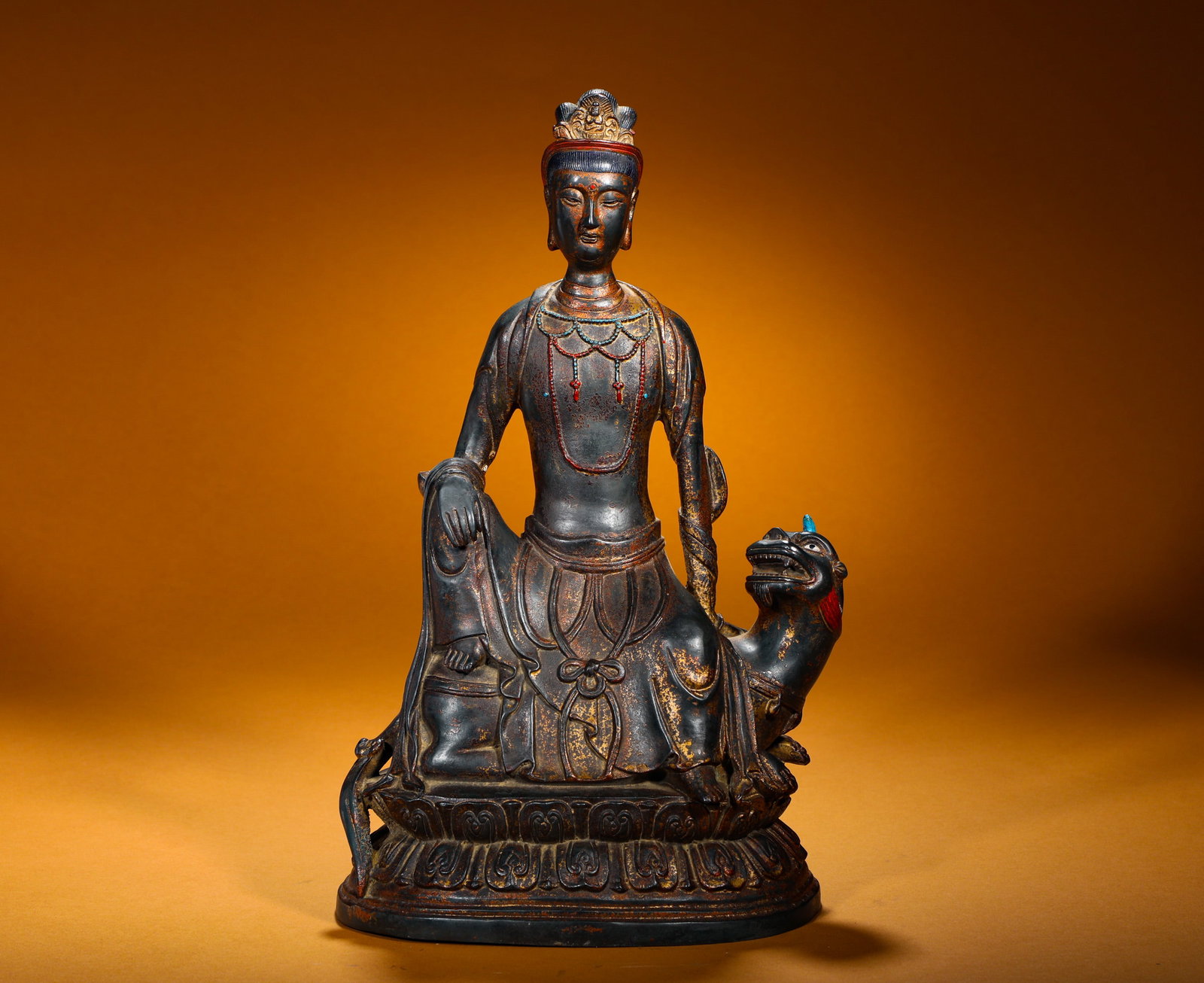 A GILDED BRONZE SEATED STATUE OF MANJUSRI BODHISATTVA FROM THE QING DYNASTY: Height:35cm(13.78in) Width:22cm(8.66in) Weight:3250g(7.16lb)Gilt bronze seated Manjushri statue. Bronze body with worn gold gilding, Buddha crown and gem-inlaid necklaces. The Bodhisattva sits in rela