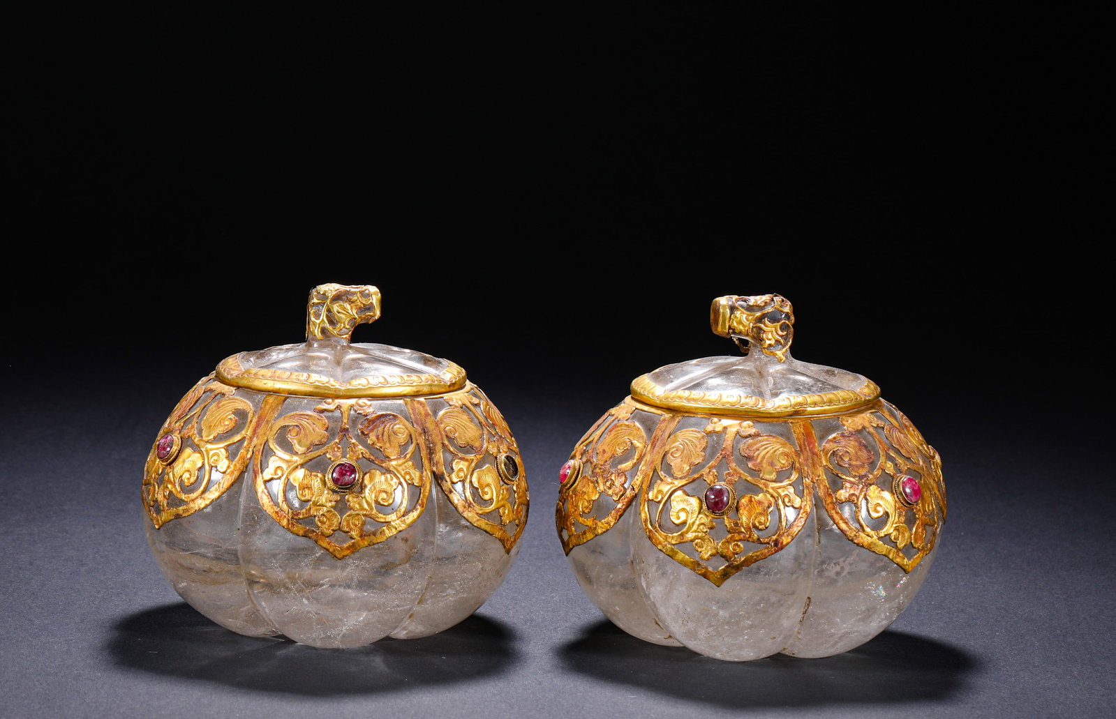 TANG DYNASTY WHITE CRYSTAL GILDED AND INLAID PUMPKIN-SHAPED LID JAR: H:9.5cm(3.74in) W:11.0cm(4.33in) Weight:1540g(3.40lb)This pair of boxes is a top-tier heavy vessel of Tang Dynasty Silk Road culture, carved from a single piece of natural rock crystal. The shape imit