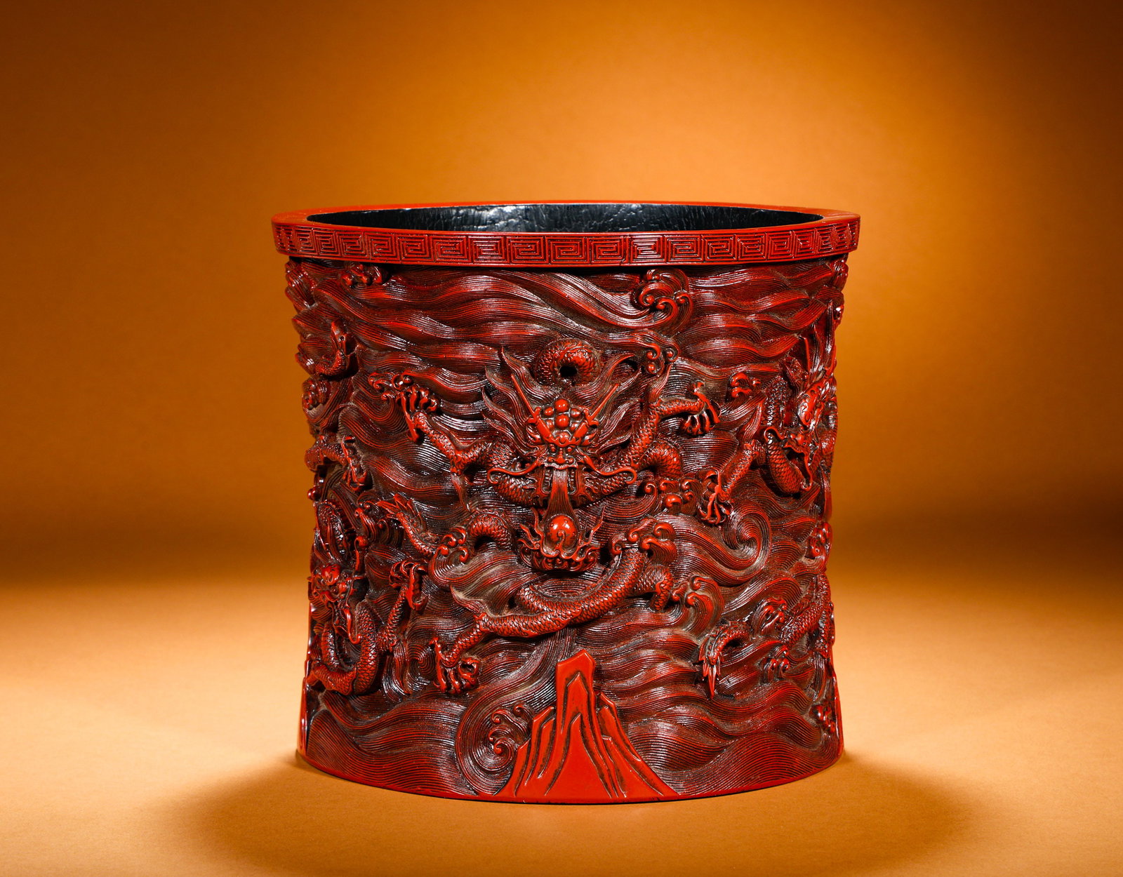 QING DYNASTY CRIMSON SEA DRAGON PEN HOLDER: Height:23cm(9.06in) Width:24.5cm(9.65in) Weight:2400g(5.29lb)Carved red lacquer brush pot decorated with dragon and sea wave patterns. Wooden core coated with thick layers of vermilion lacquer before 