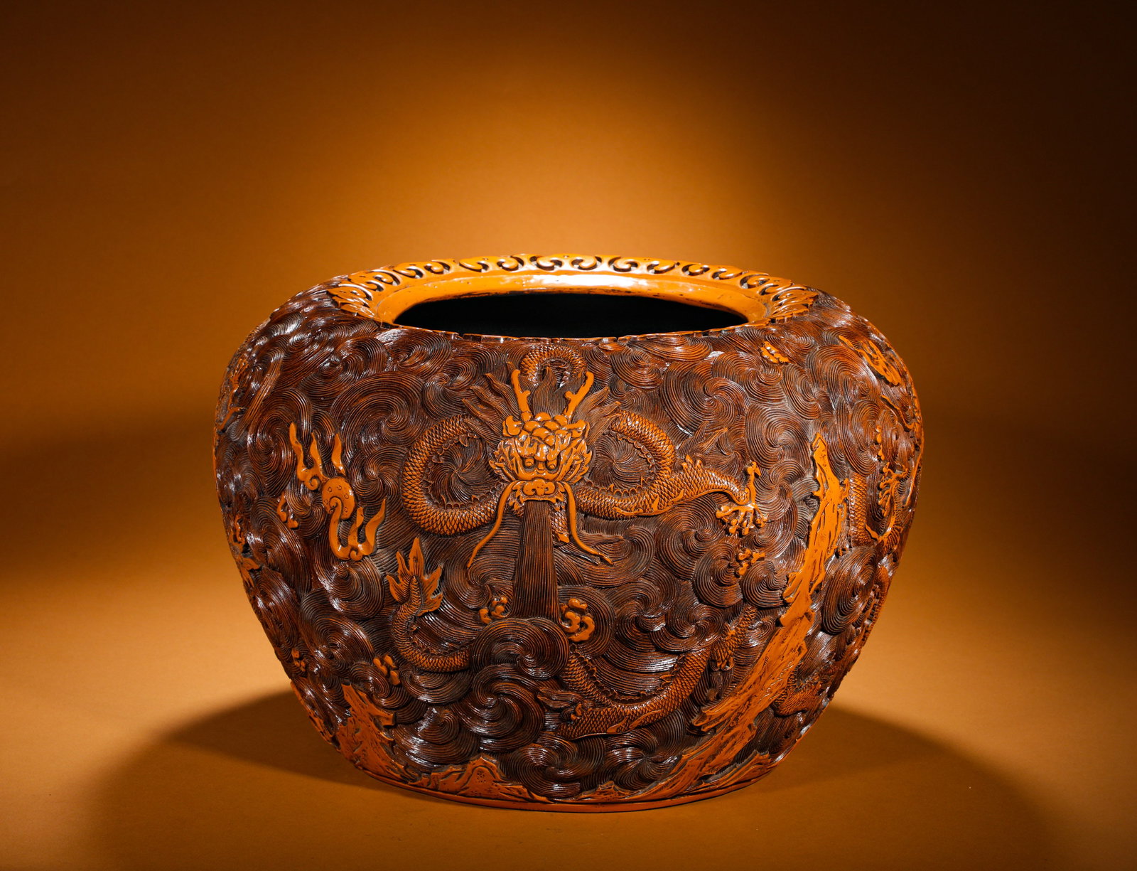 A LARGE VASE WITH YELLOW SEA WATER DRAGON PATTERNS CARVED BY EMPEROR QIANLONG OF THE QING DYNASTY: Height:33cm(12.99in) Width:50cm(19.69in) Weight:8560g(18.87lb)Qing Dynasty Qianlong-marked carved yellow lacquer vat. Wooden core layered with yellow lacquer and deep relief carved dragon-and-wave lan