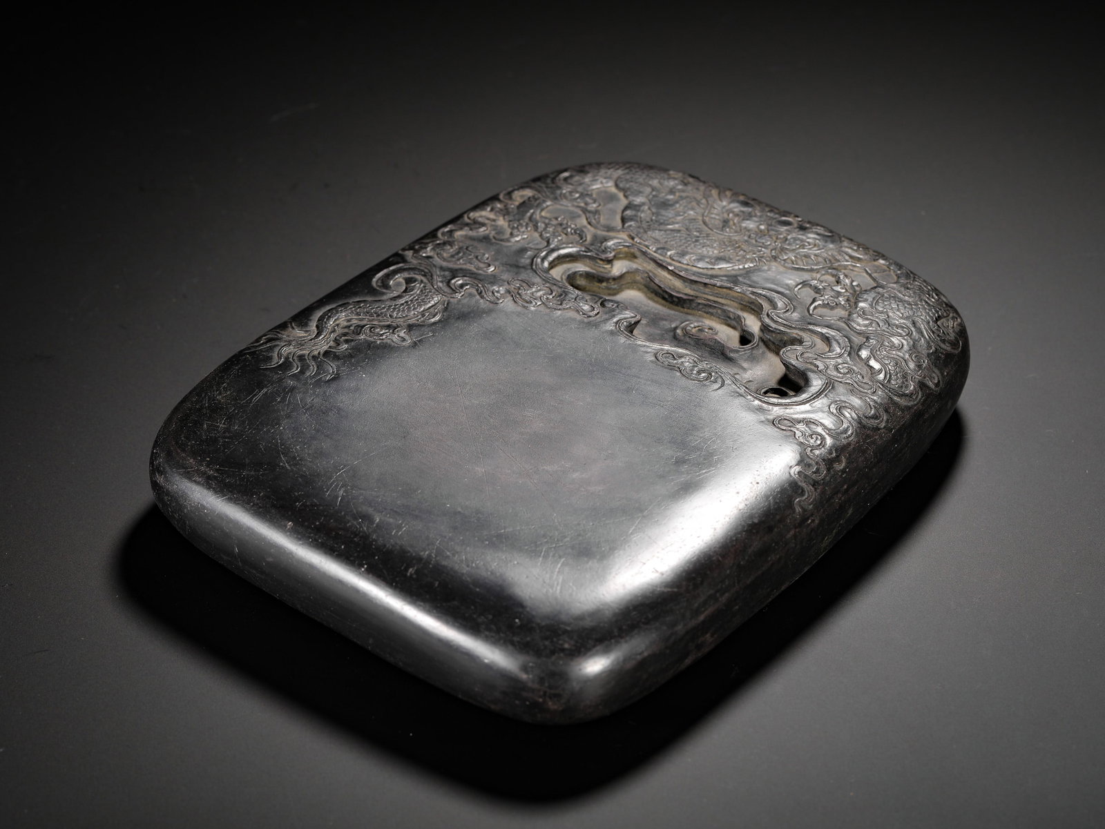 SEAL BY CHEN JIEQI OF THE QING DYNASTY, ANCIENT INKSTONE OF THE STUDY: Long:22cm(8.66in) Width:17.5cm(6.89in) Weight:3420g(7.54lb)Duan inkstone carved cloud-dragon pattern, cursive poetry and Chen Jieqi seal on reverse, ancient scholar's stone
