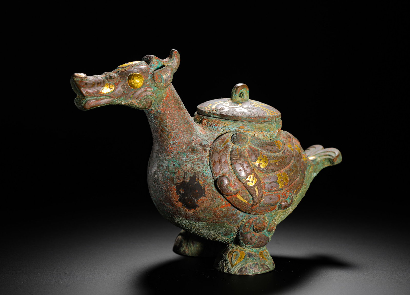 BRONZE INLAID GOLD AND SILVER AUSPICIOUS BEAST SHAPE FROM THE WARRING STATES PERIOD ?B: H:15cm (5.91in) W:20cm (7.87in) Weight:1370g (3.02lb)This he vessel is a Warring States Period bronze ritual object. Shaped like a mythical beast, its entire body is decorated with feather and scale p